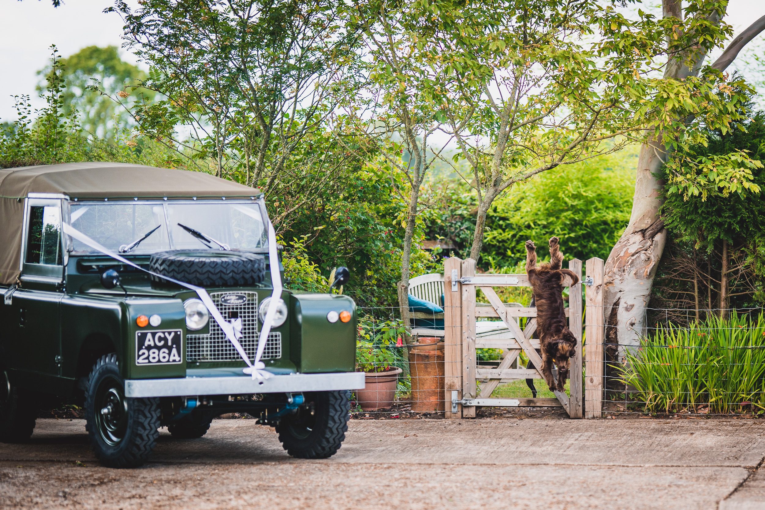 A green land rover parked at a wedding venue.