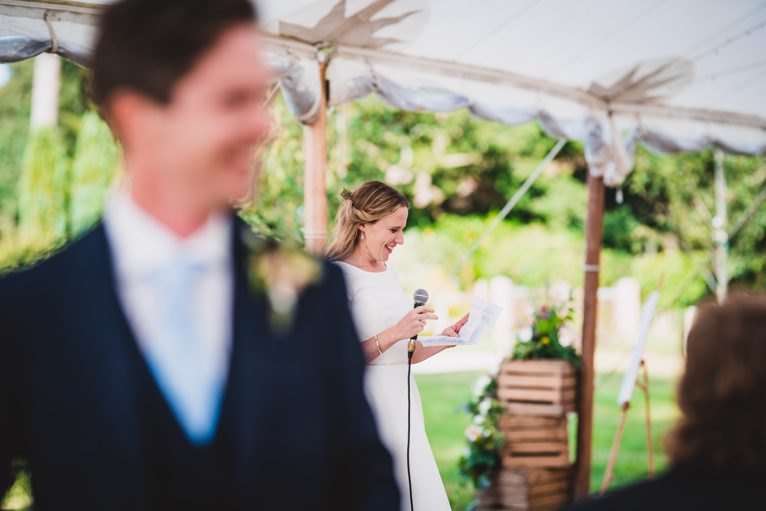 A wedding photo featuring a bride and groom standing in front of a tent.