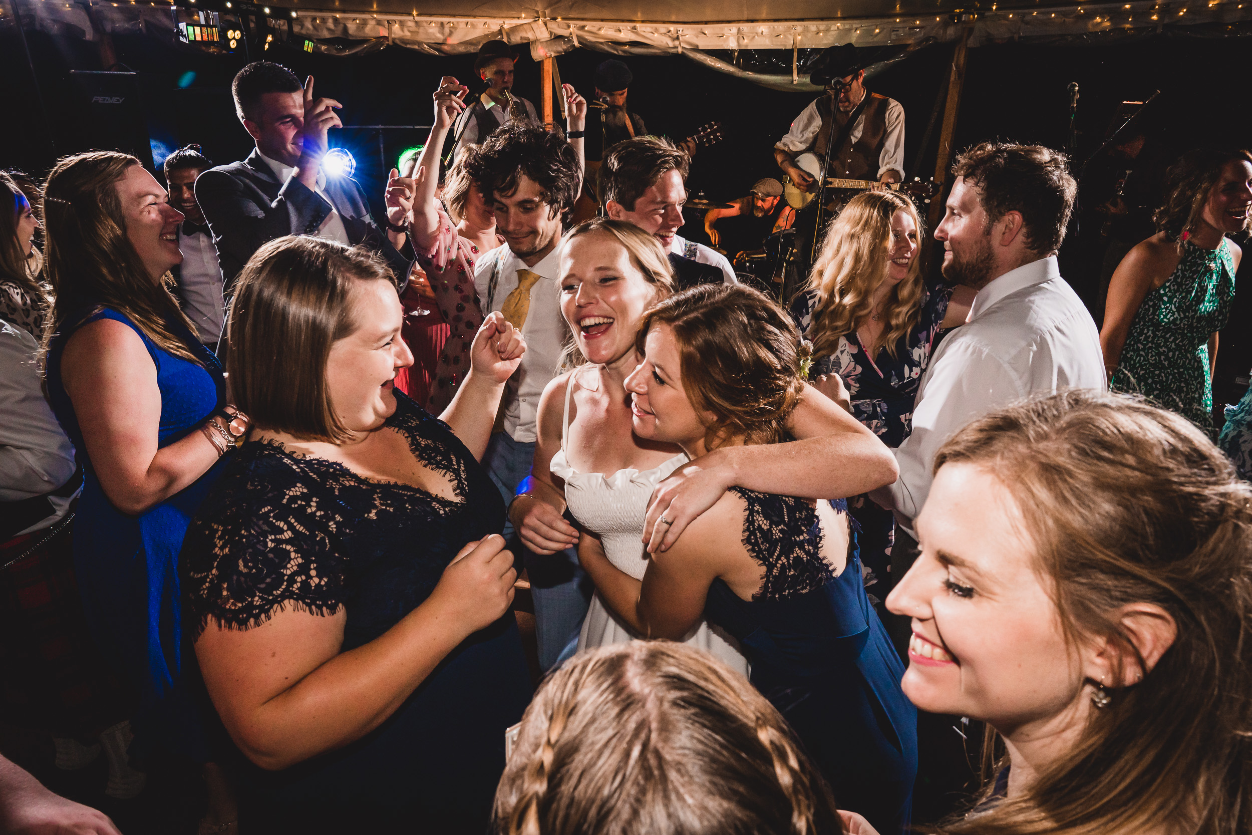 A wedding photographer captures the joyful dances of brides and grooms at a reception.