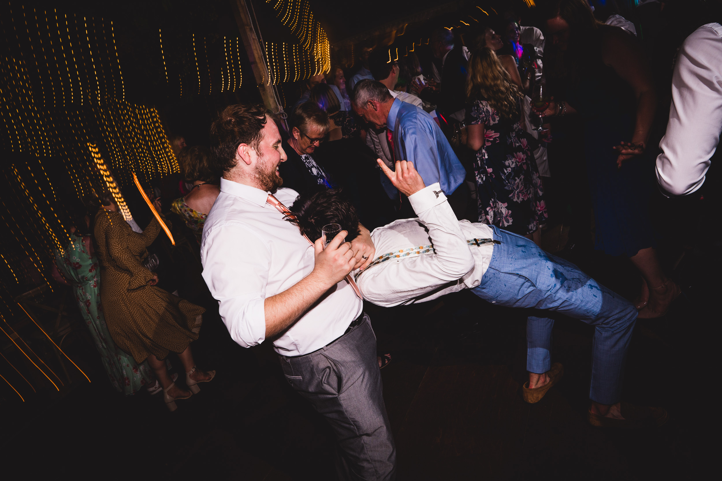 The groom and his wedding photographer dance on the dance floor at a wedding.