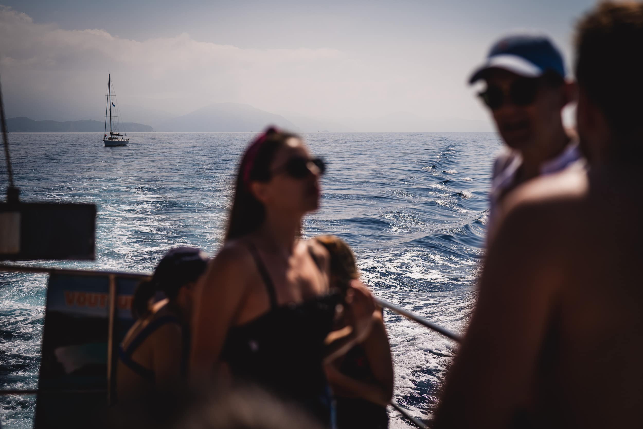 A group of people, including the bride, on a boat during a wedding ceremony at sea.