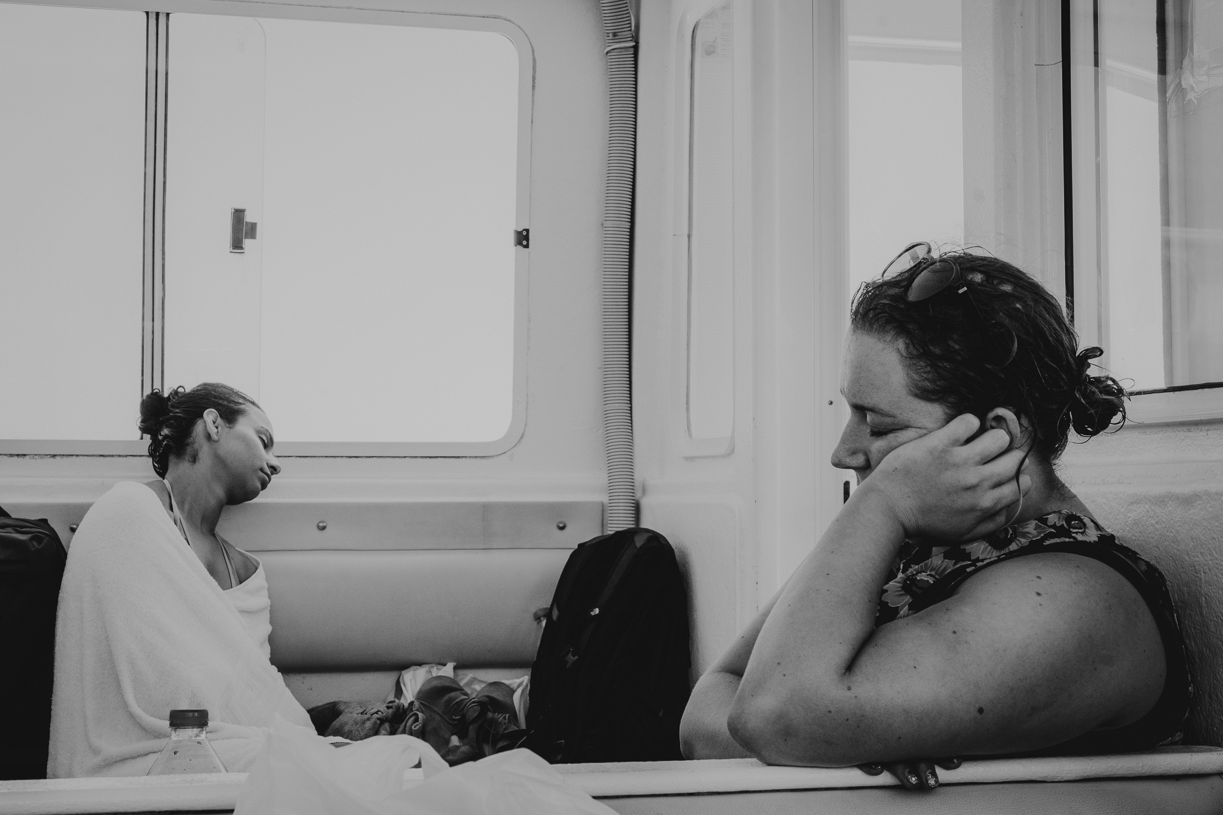 A bride is talking on the phone while sitting on a boat at her wedding.