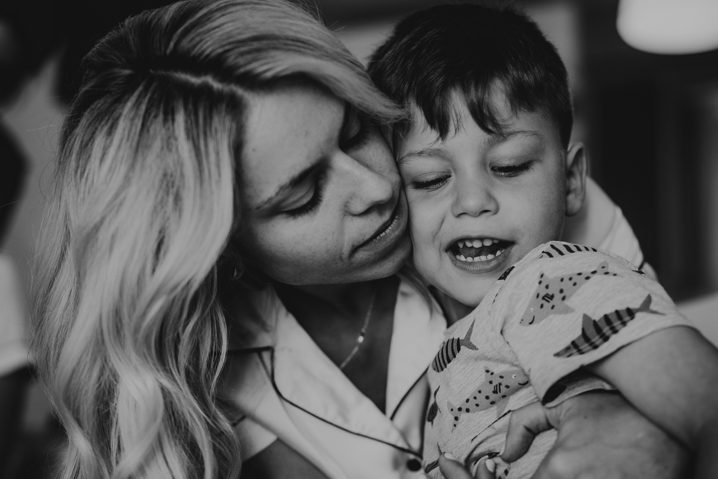 Black and white wedding photo of a bride hugging her son.