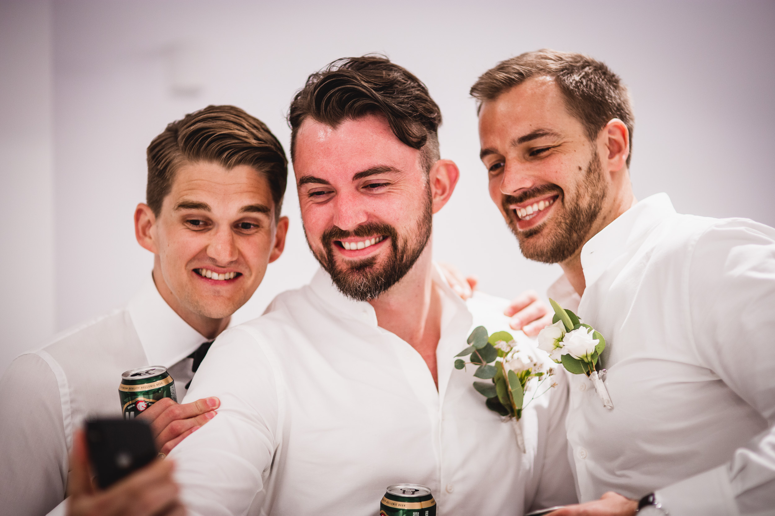 Groomsmen capturing a selfie at a wedding.