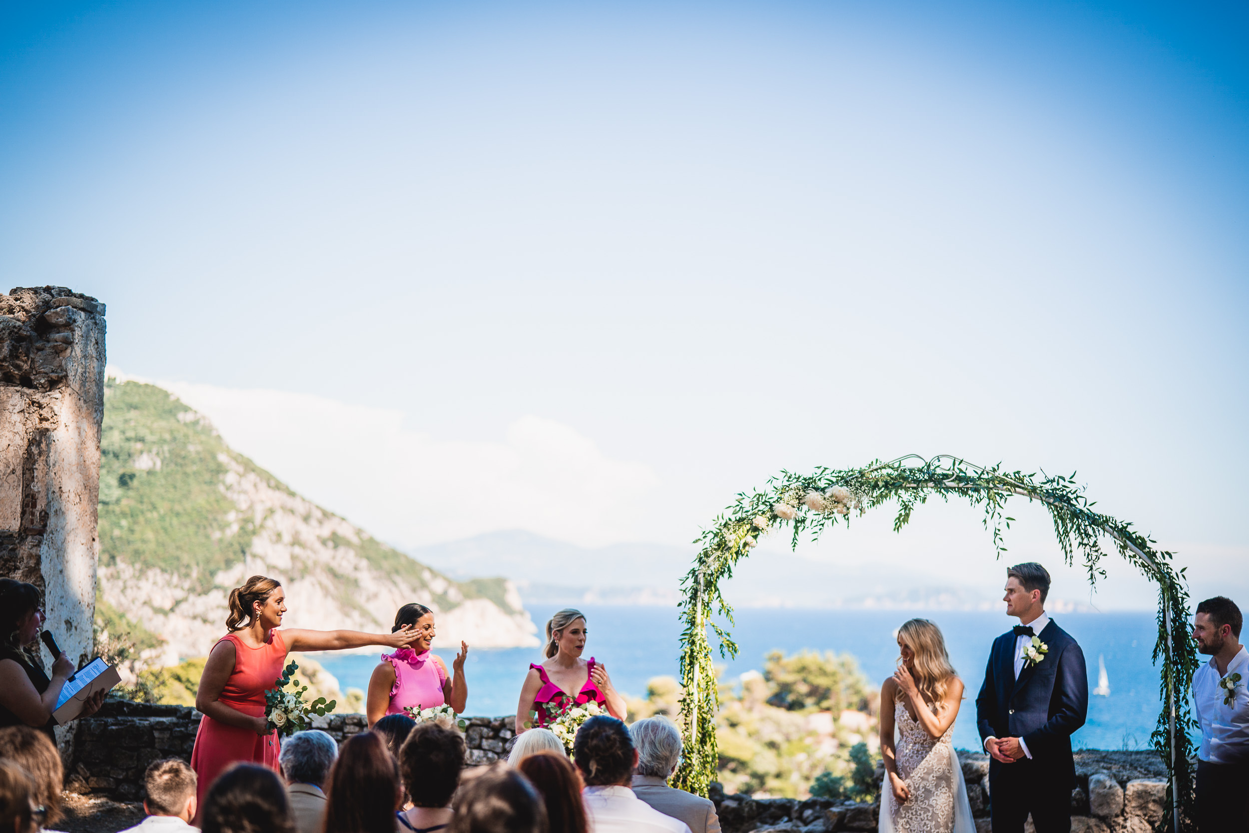 A bride and groom exchange vows during a stunning cliffside wedding ceremony, expertly captured by a wedding photographer.