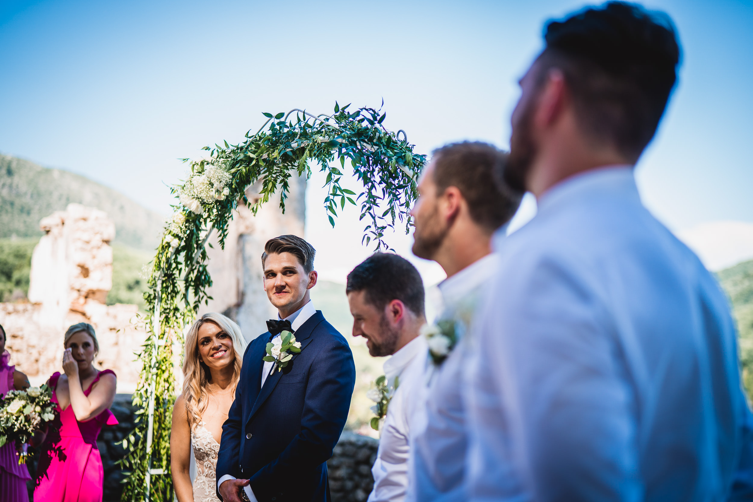 A groom and bride share a tender moment during their wedding ceremony, captured in a stunning wedding photo.