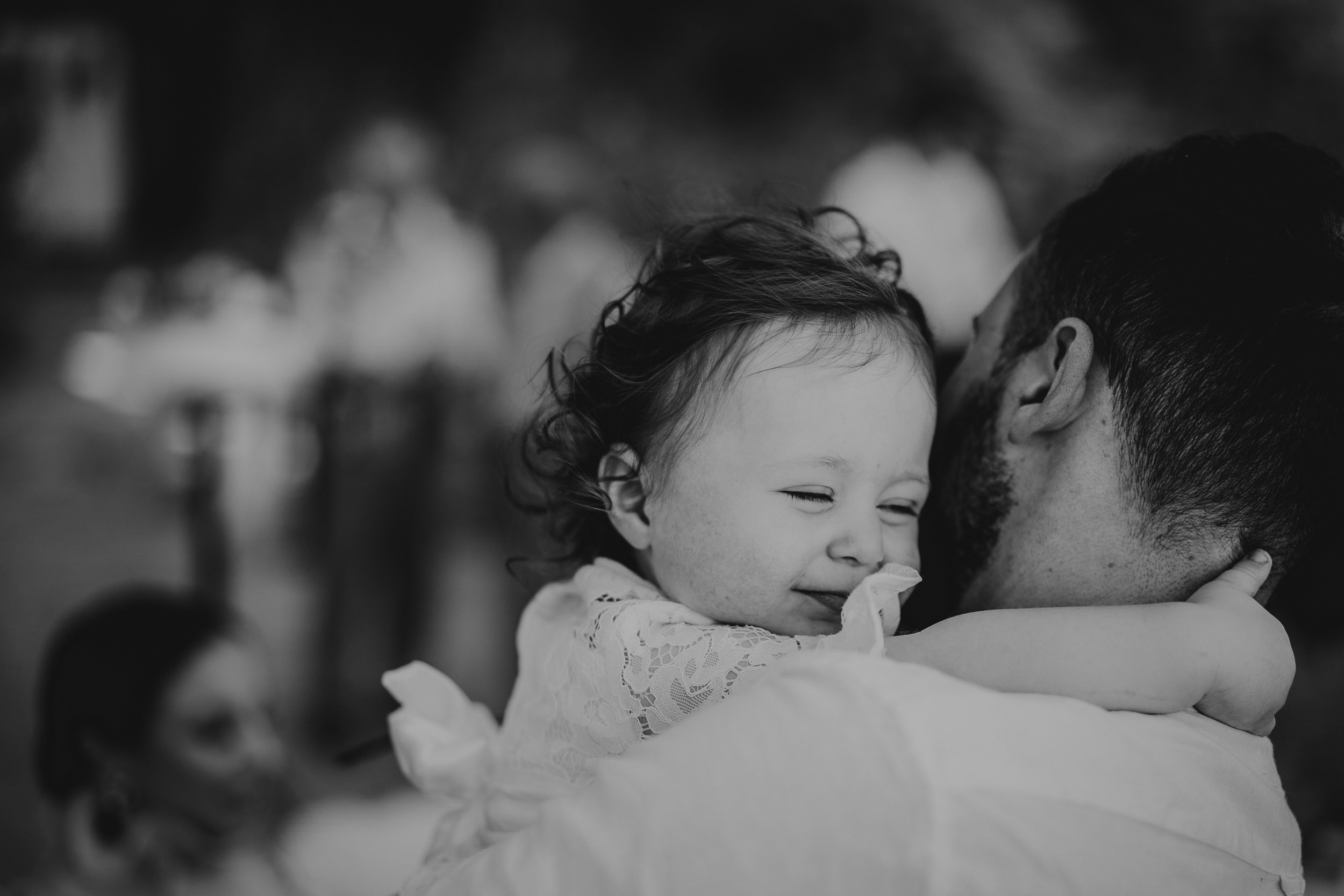Black and white photo of a groom hugging a little girl.