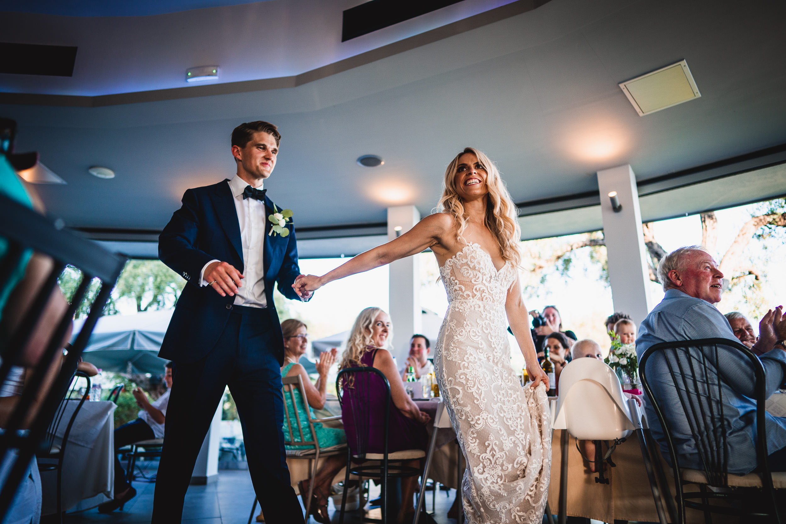 A wedding photo capturing the bride and groom walking down the aisle at their reception.