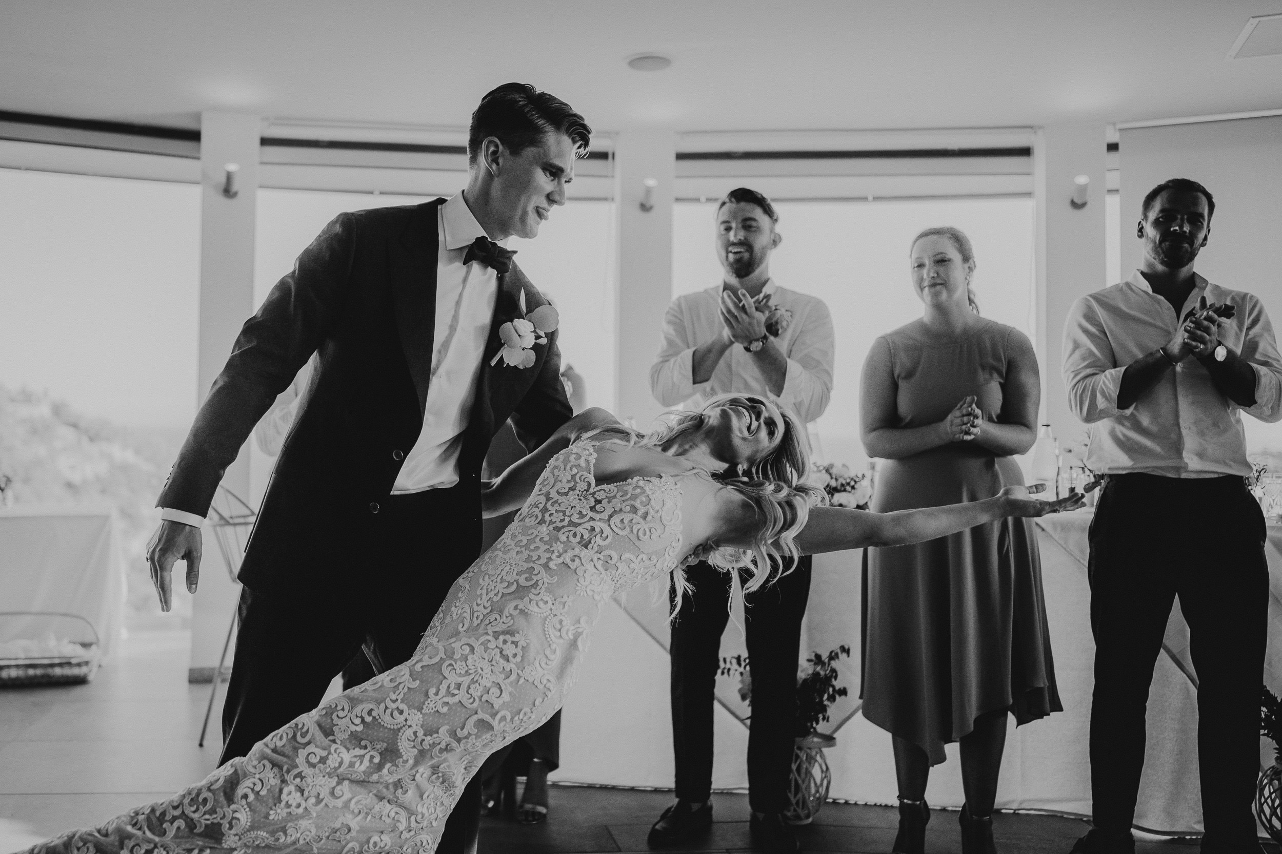 A wedding photographer capturing a bride and groom dancing at their wedding reception.