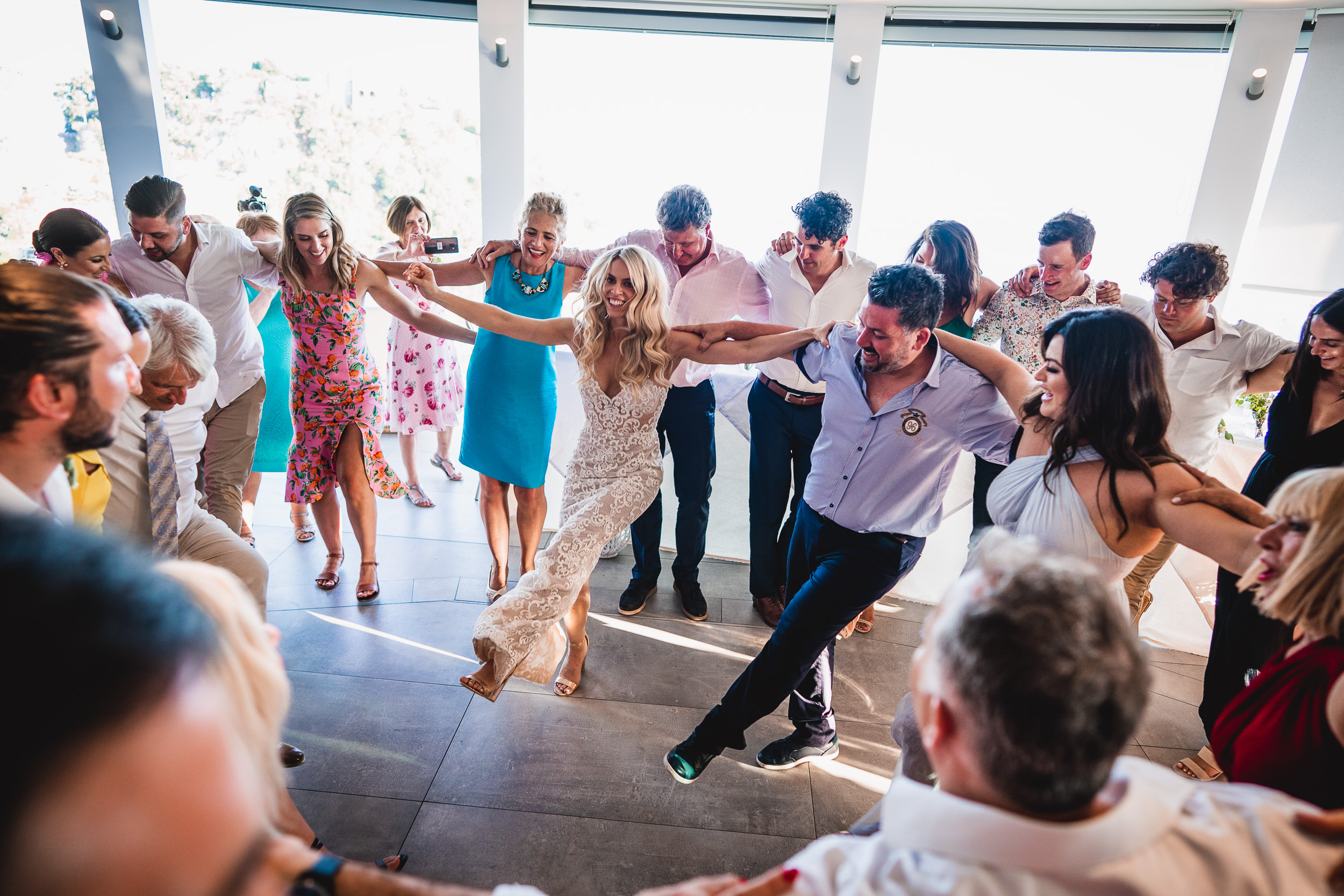 A group of people dancing at a wedding reception, photographed by the wedding photographer.