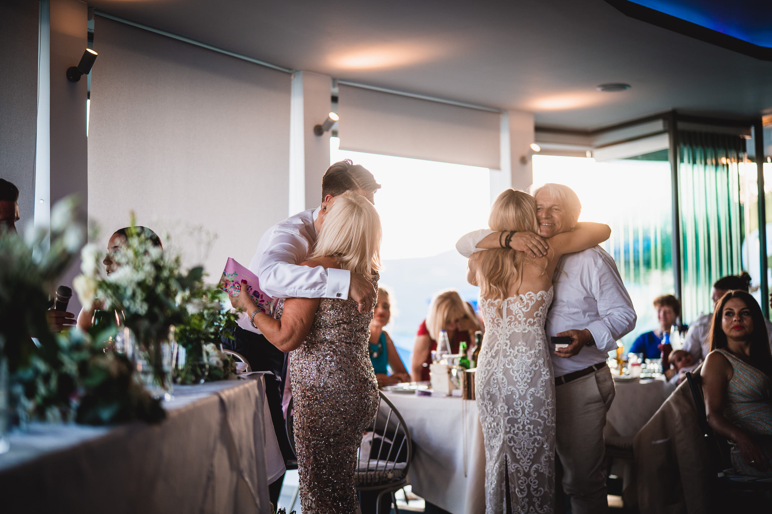 A groom embracing his bride at a joyous wedding celebration photographed by the wedding photographer.