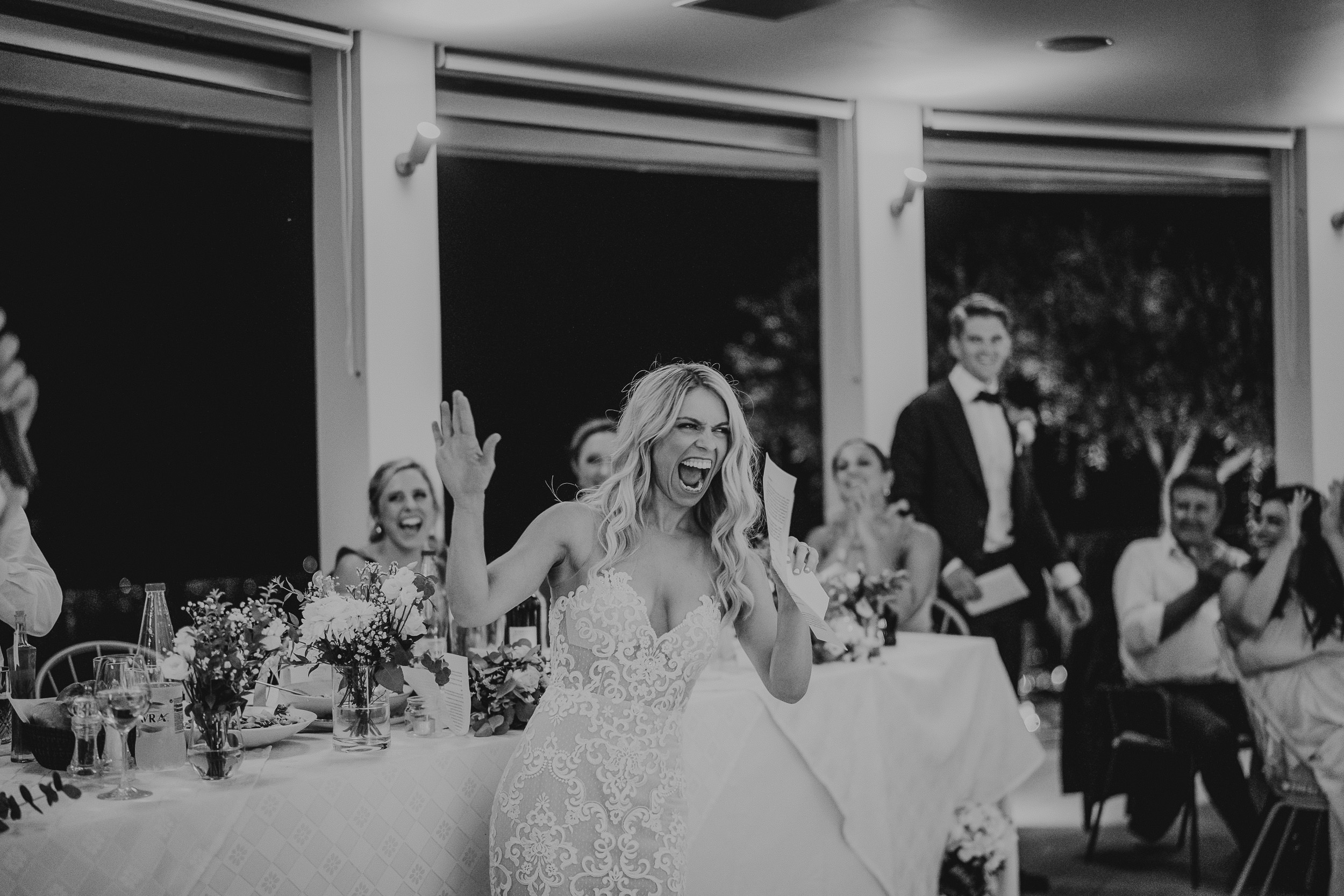 A joyful bride applauding at her wedding reception.