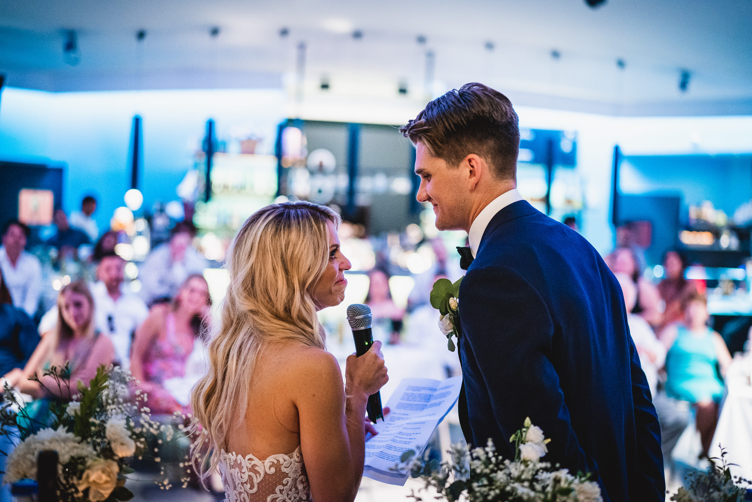 A groom and bride delivering a heartfelt speech during their wedding reception, captured in a beautiful wedding photo.