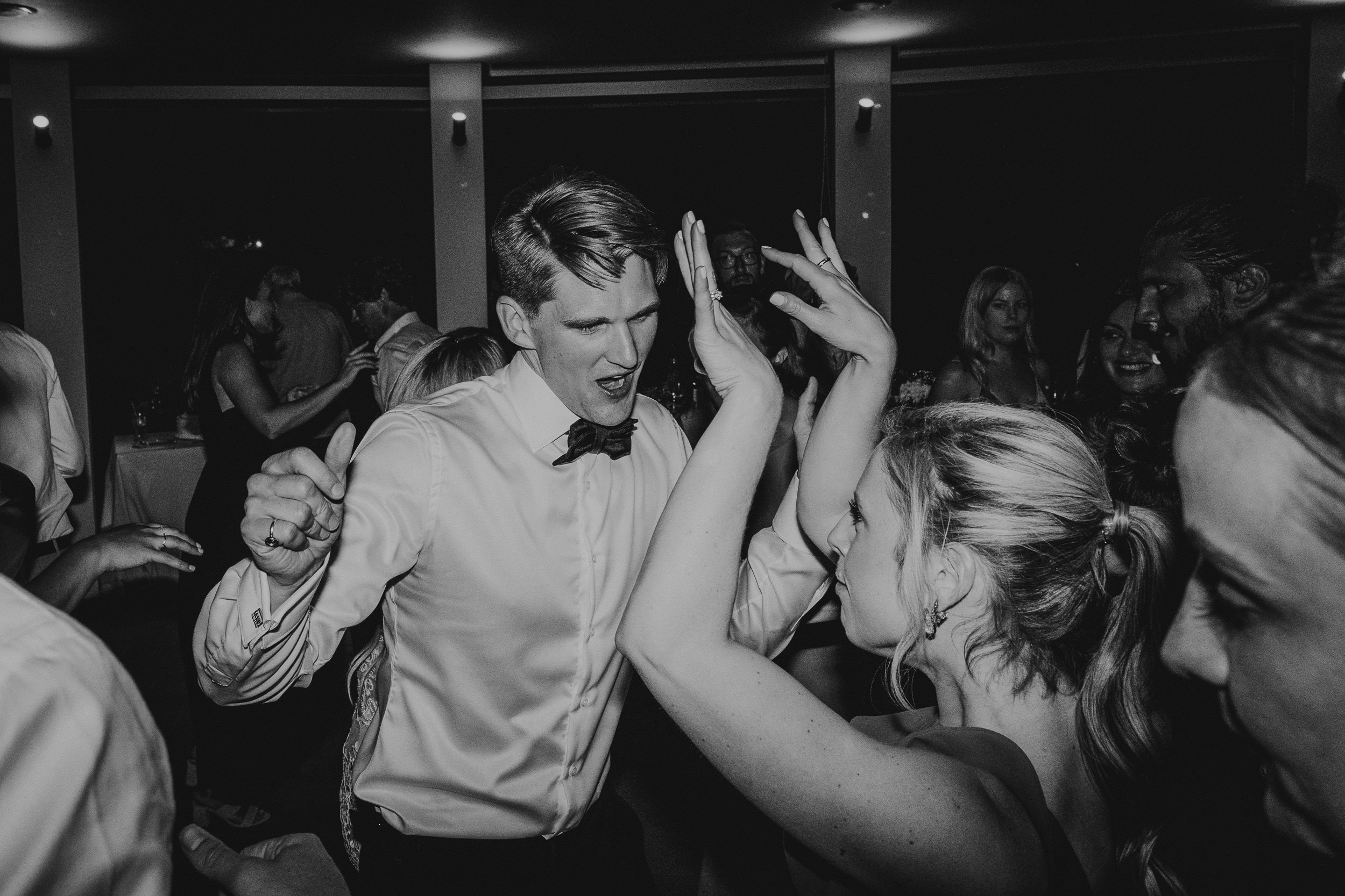 A black and white photo capturing a couple's dance at a wedding, taken by a wedding photographer.