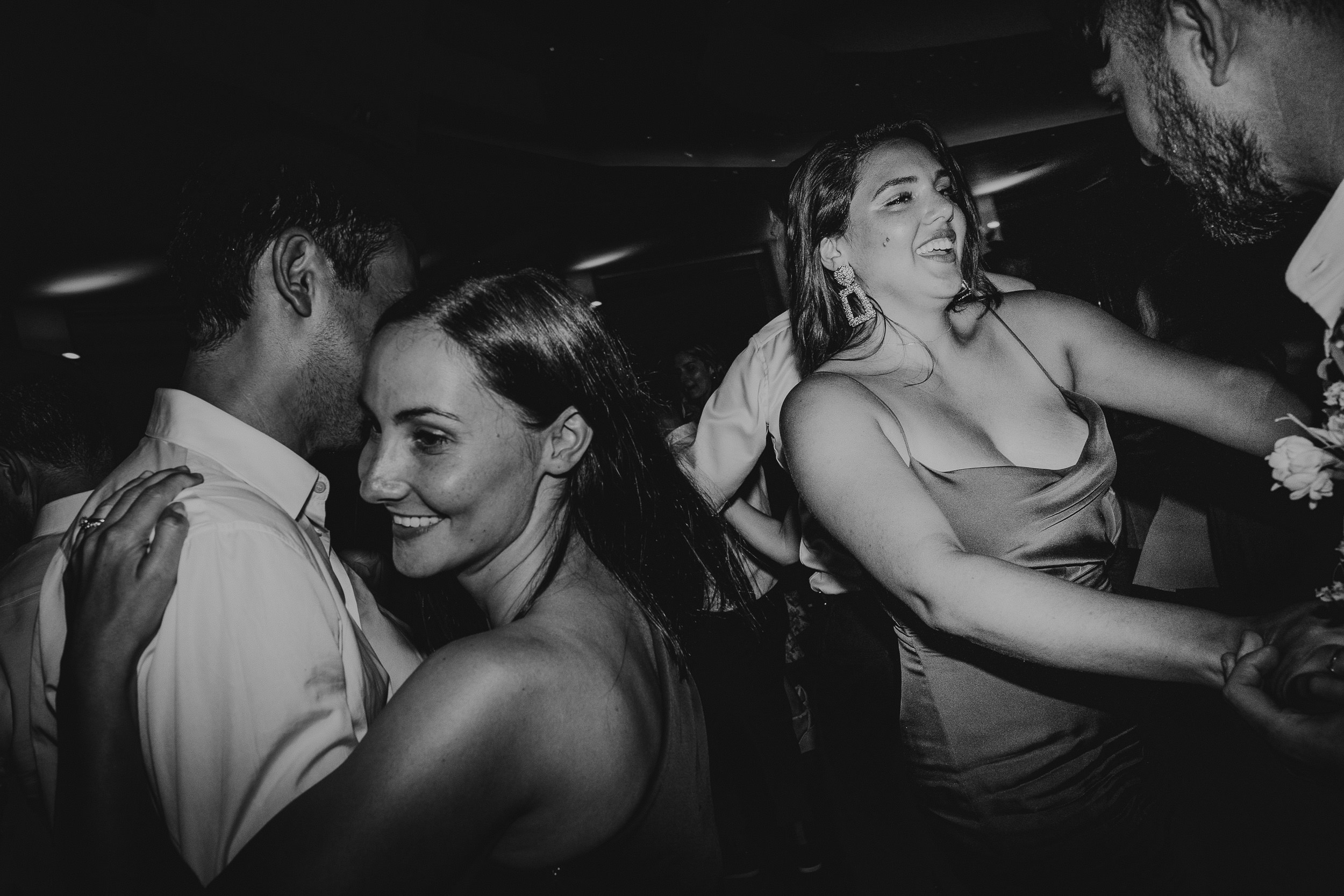 A black and white wedding photo capturing the bride and groom dancing.