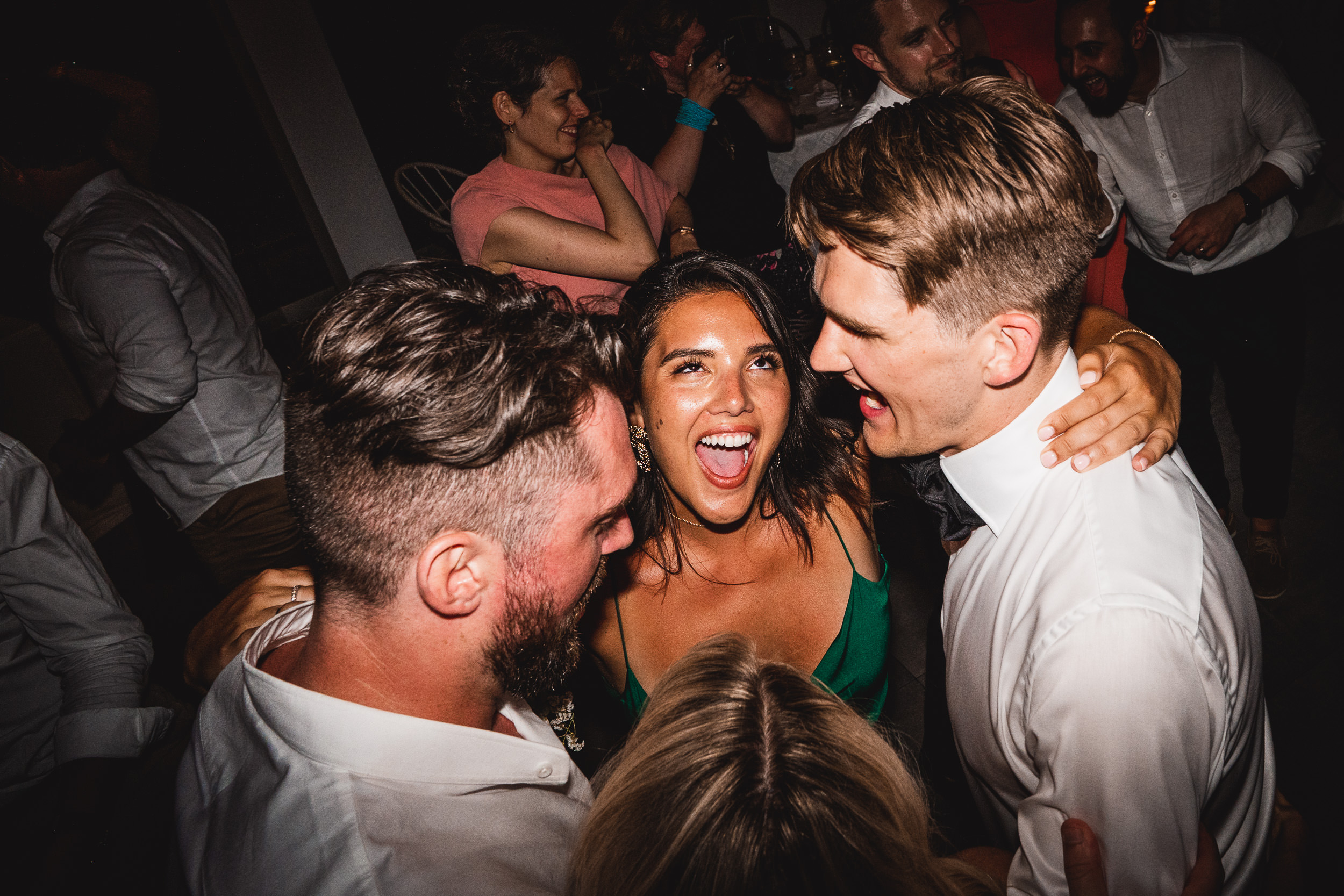 A group of people dancing at a wedding party.