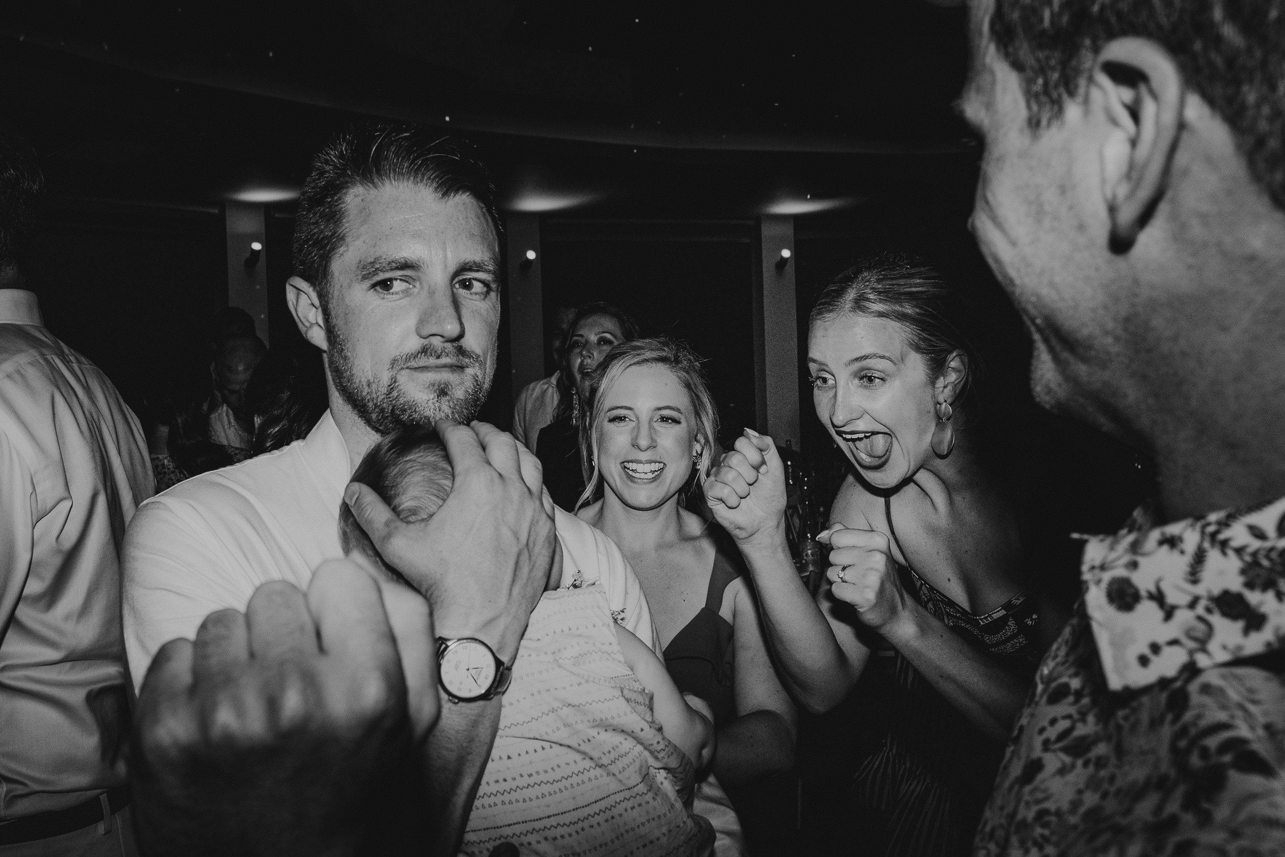 A black and white photo of a group of people at a wedding party.