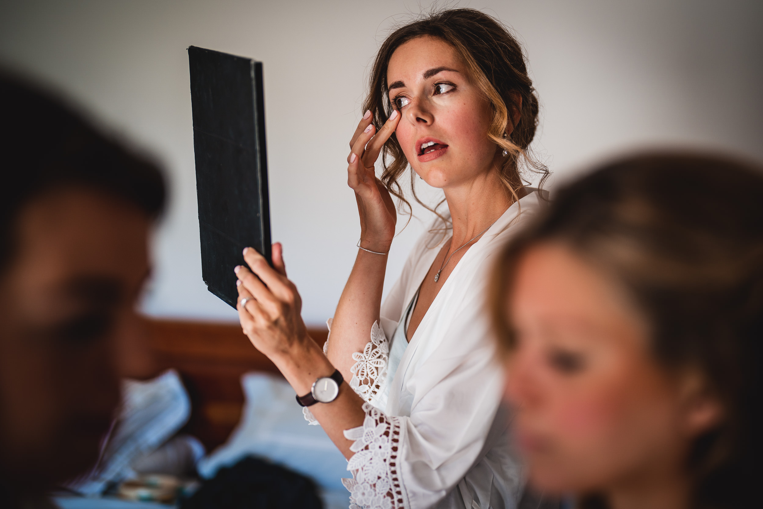 A woman is getting ready for her wedding, distractedly glancing at her phone as she waits for the groom.