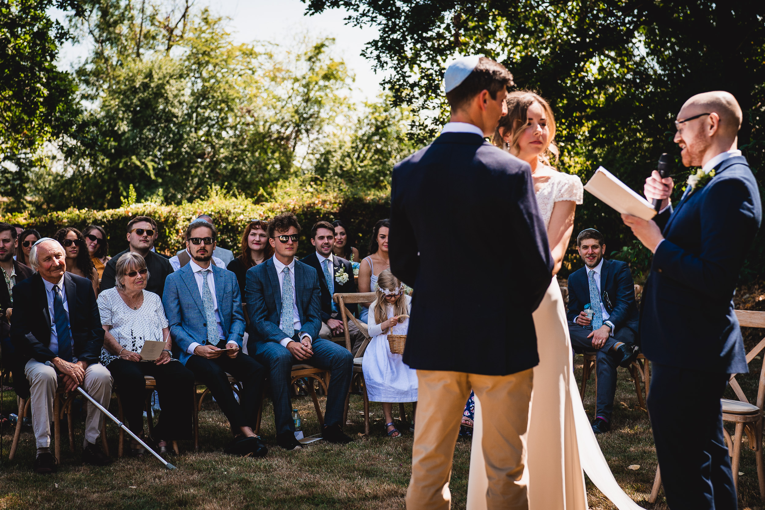 A bride and groom exchange vows in a picturesque outdoor wedding ceremony, captured in a stunning wedding photo.