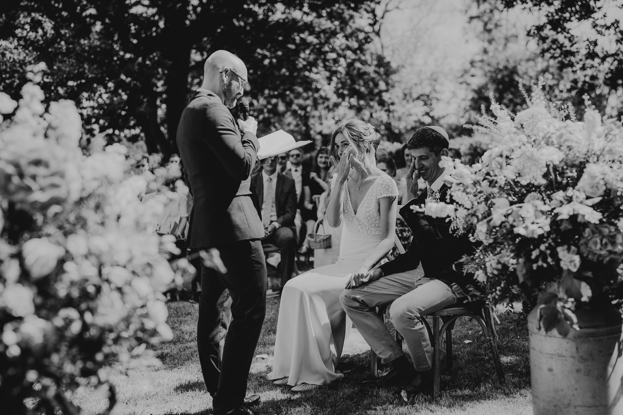A black and white wedding photograph capturing the beautiful ceremony in a garden.