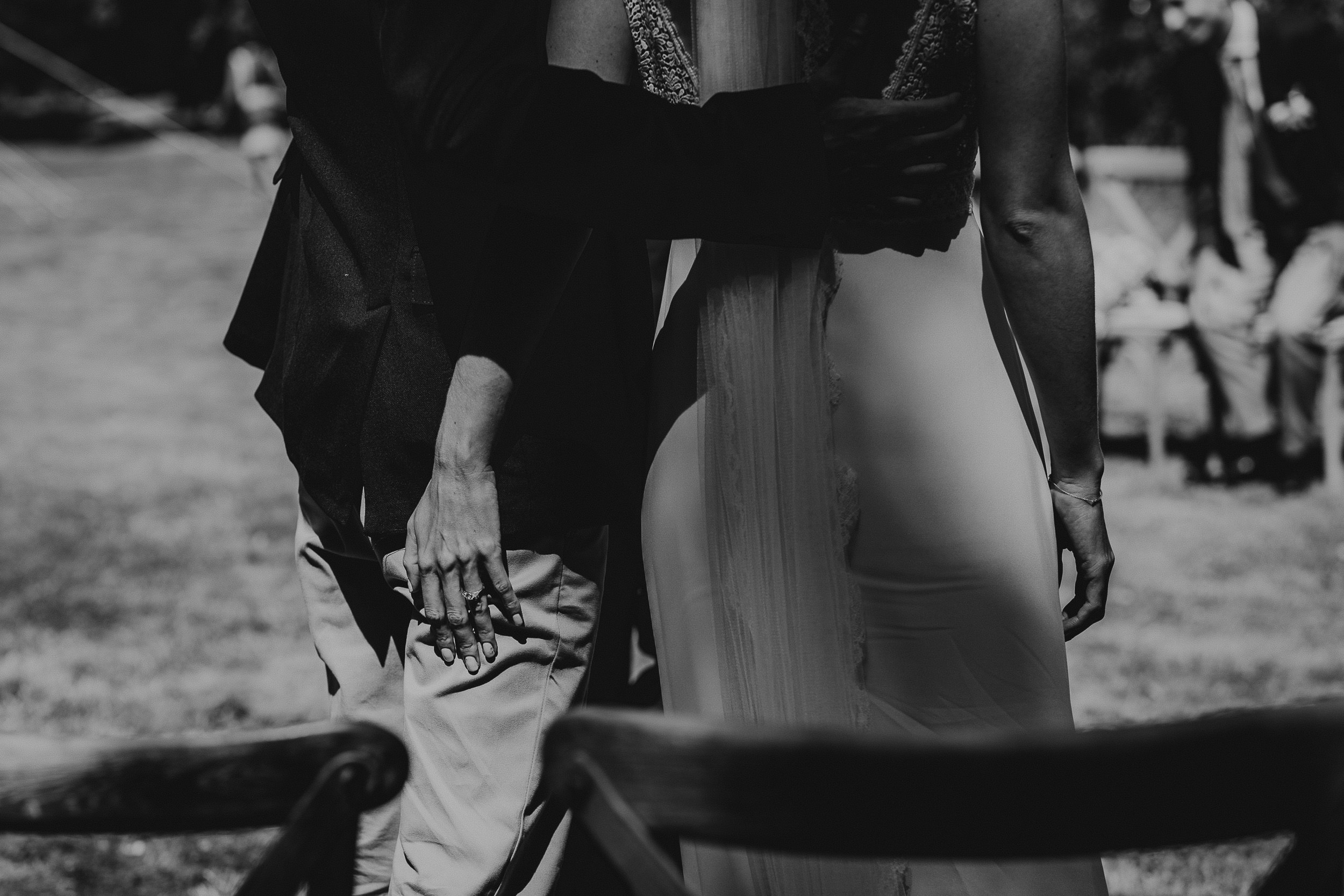 A wedding photographer captured a heartfelt moment of a bride and groom embracing in their black and white photo.