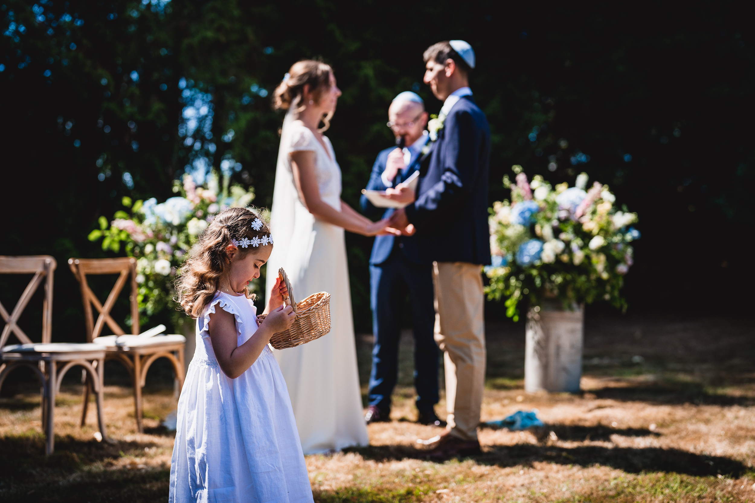 A wedding ceremony featuring a groom and a little girl at the altar, captured by the wedding photographer.