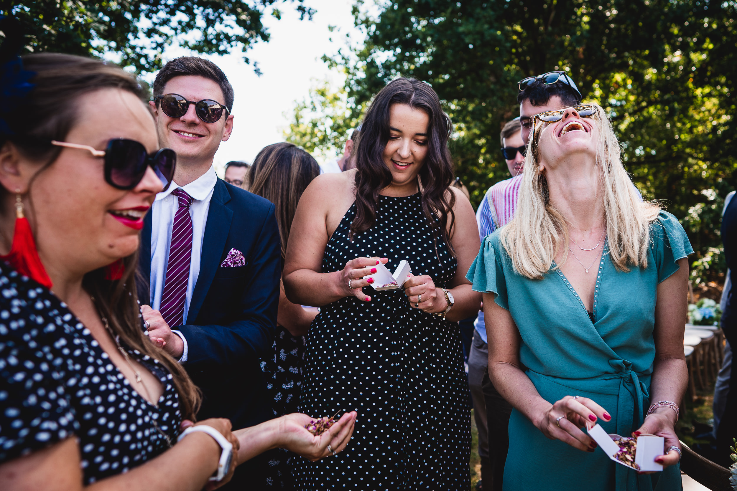 A group of people laughing at a wedding party.