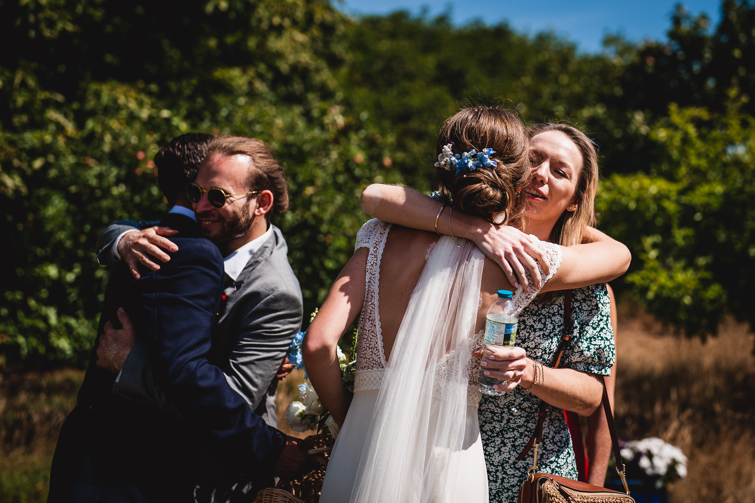 A groom embracing his bride photographed in an orchard by a wedding photographer.