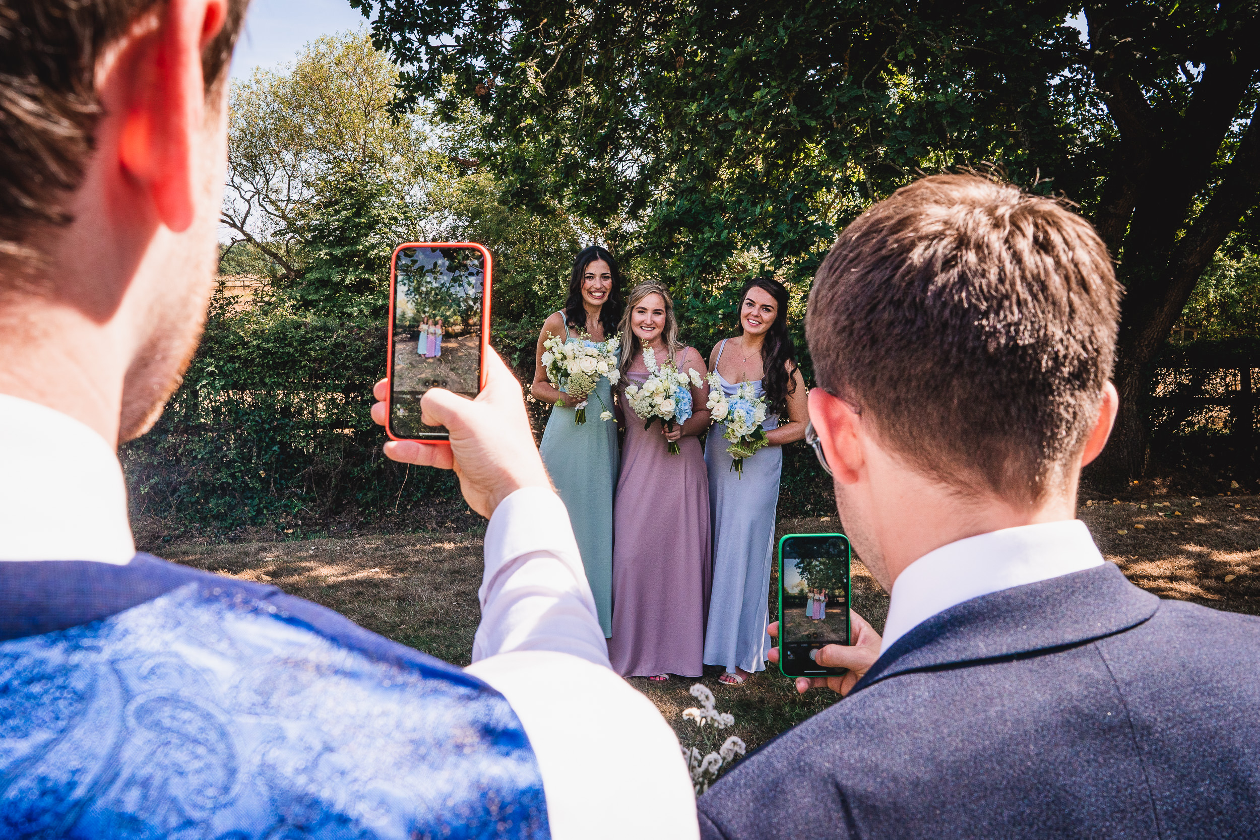 A groom and bride capturing a wedding photo with their cell phone.