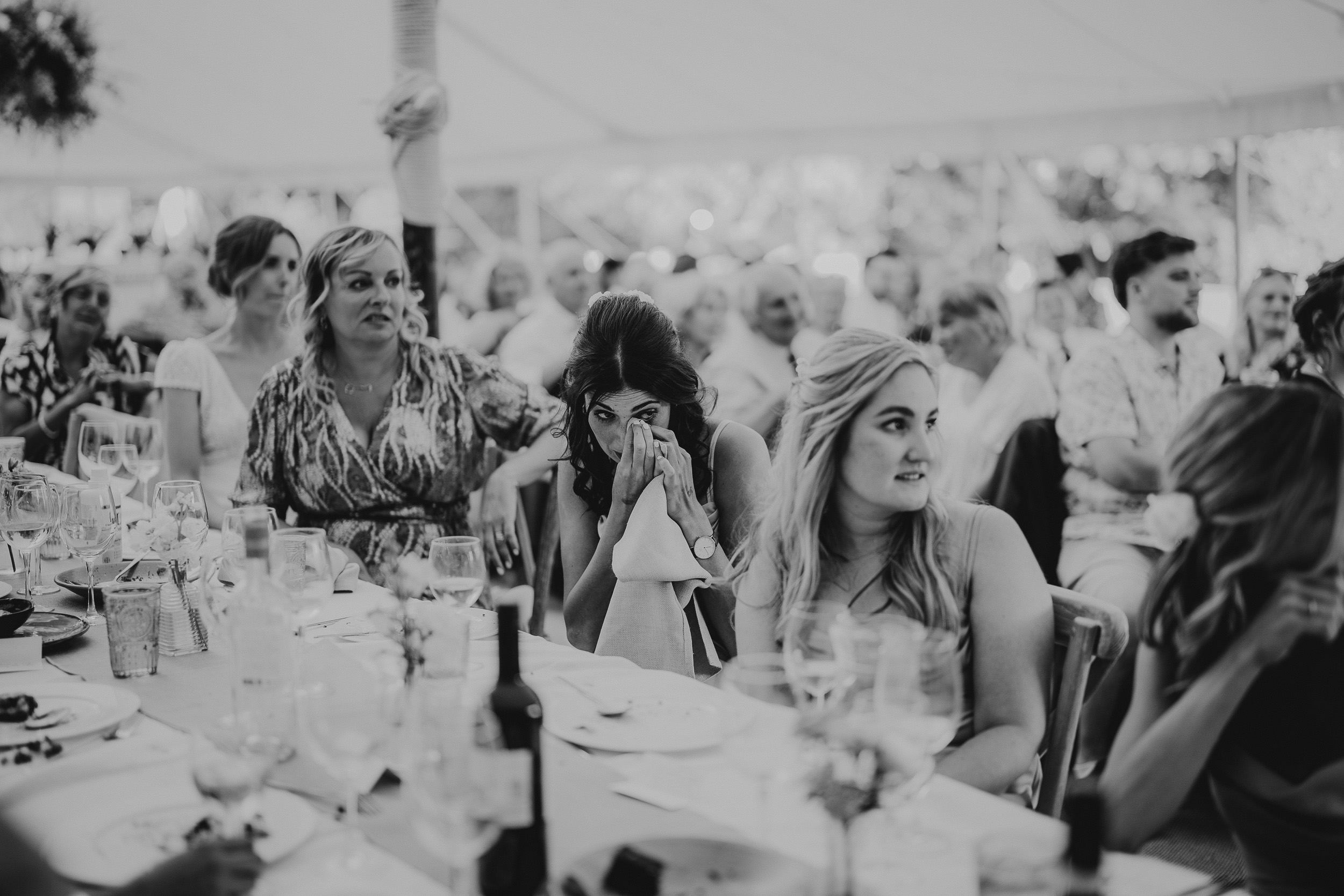 A black and white photo capturing a group of people celebrating a wedding.