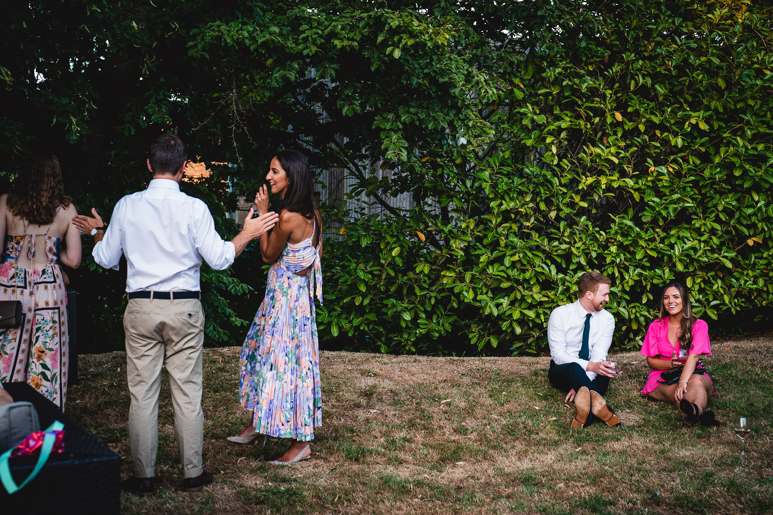 A wedding photo of a bride and the group in a grassy area.