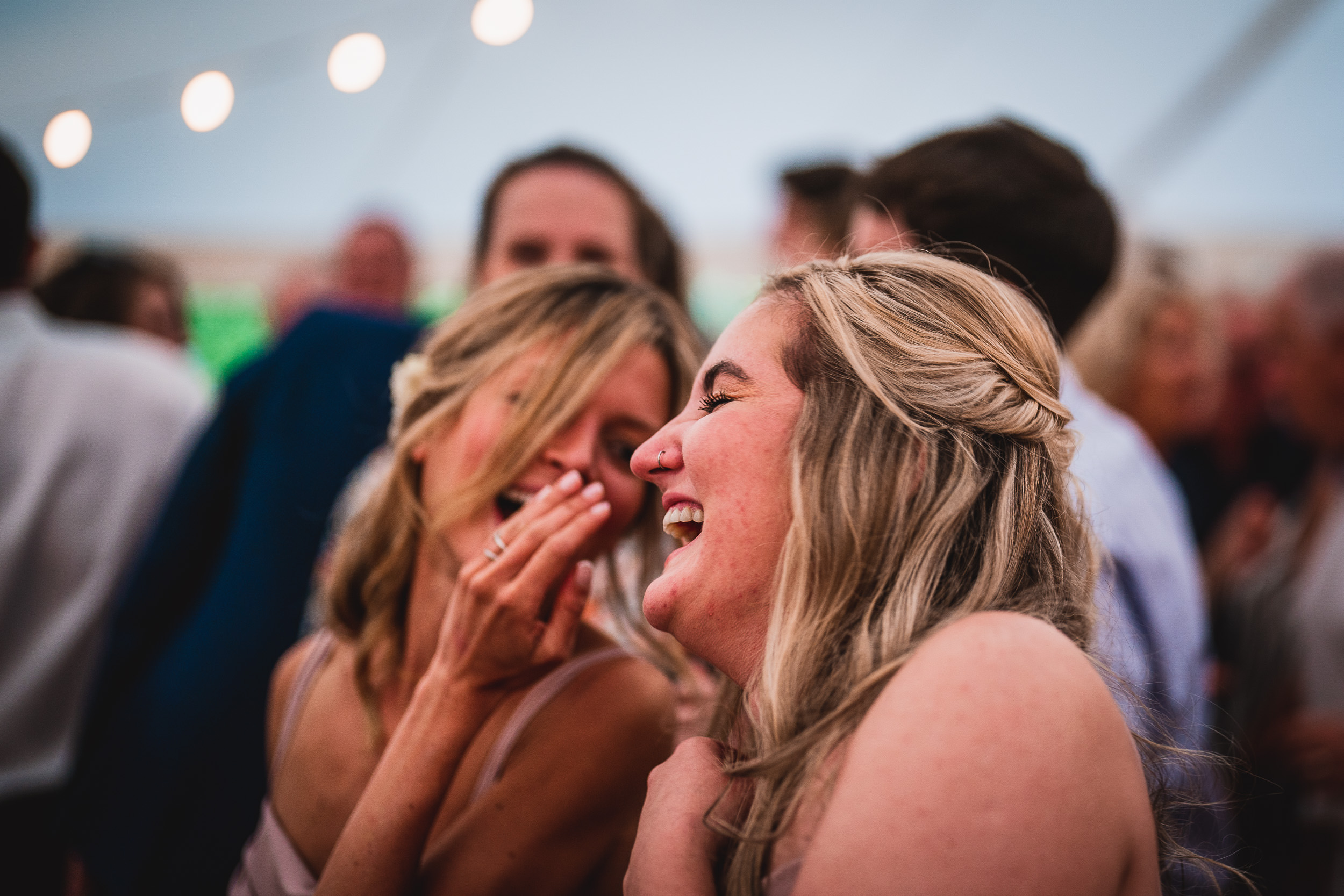 A joyful wedding photo of two brides celebrating on the dance floor.