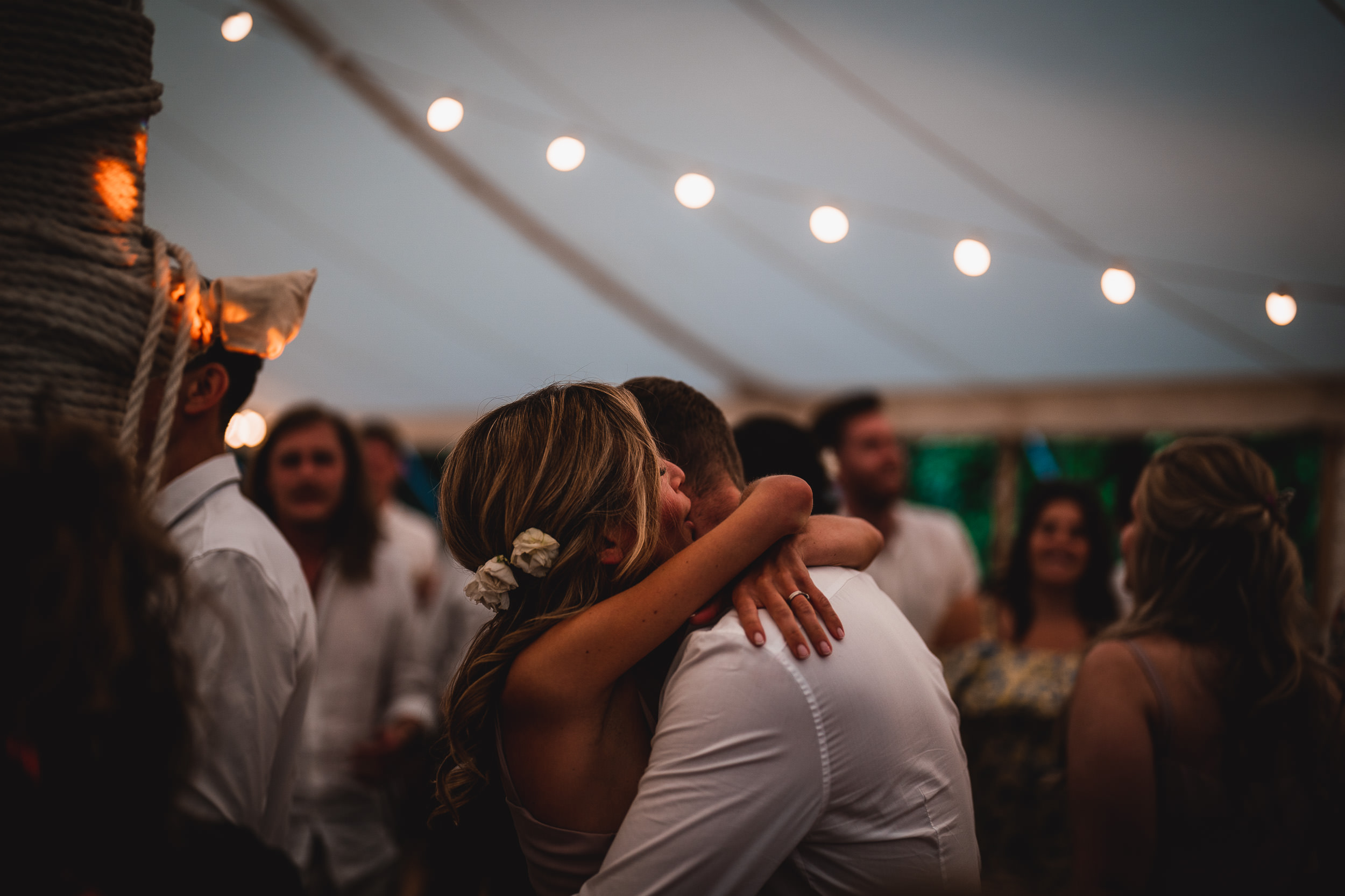 A wedding photographer capturing a bride and groom's heartfelt embrace.