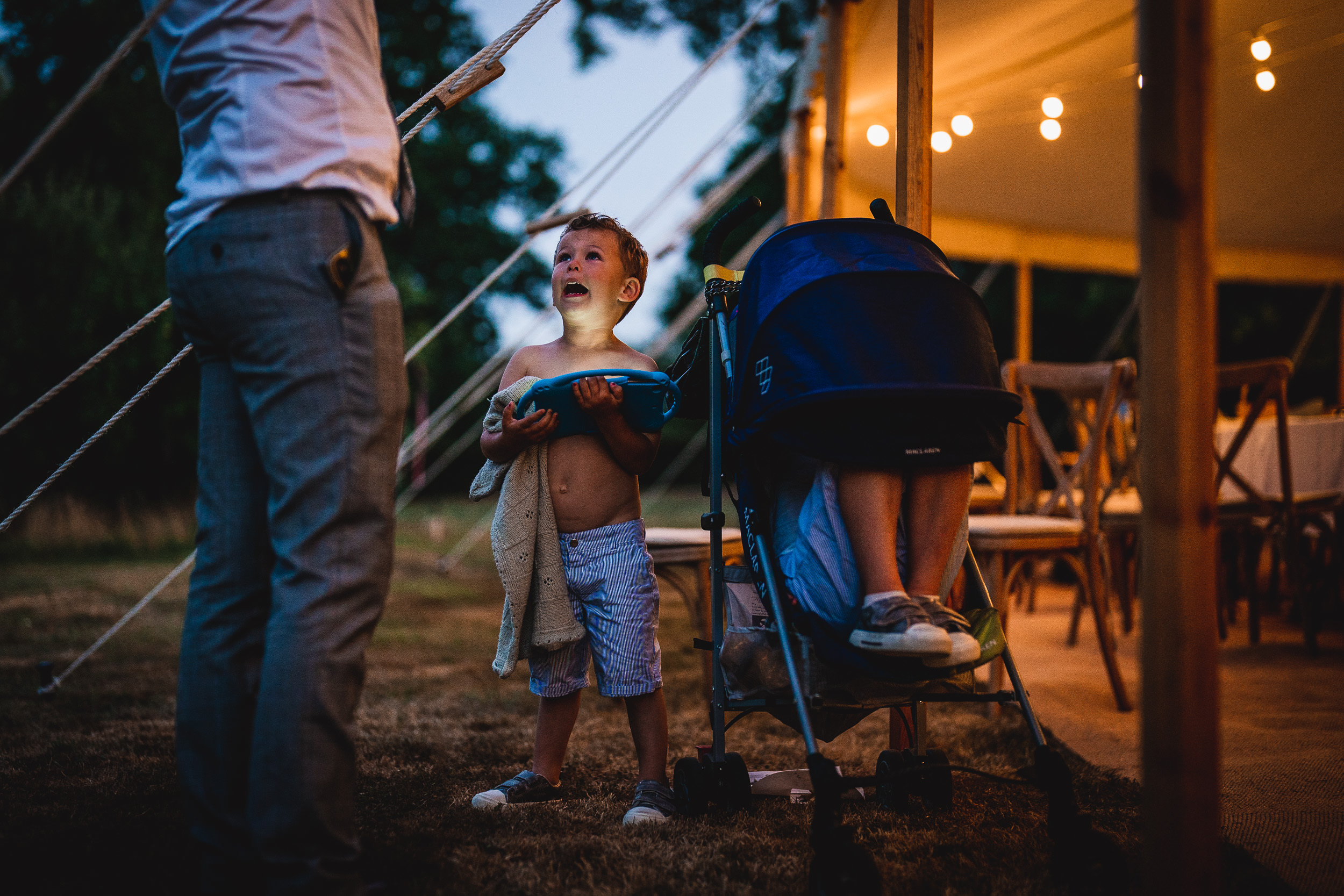 A man pushing a stroller in front of a tent.