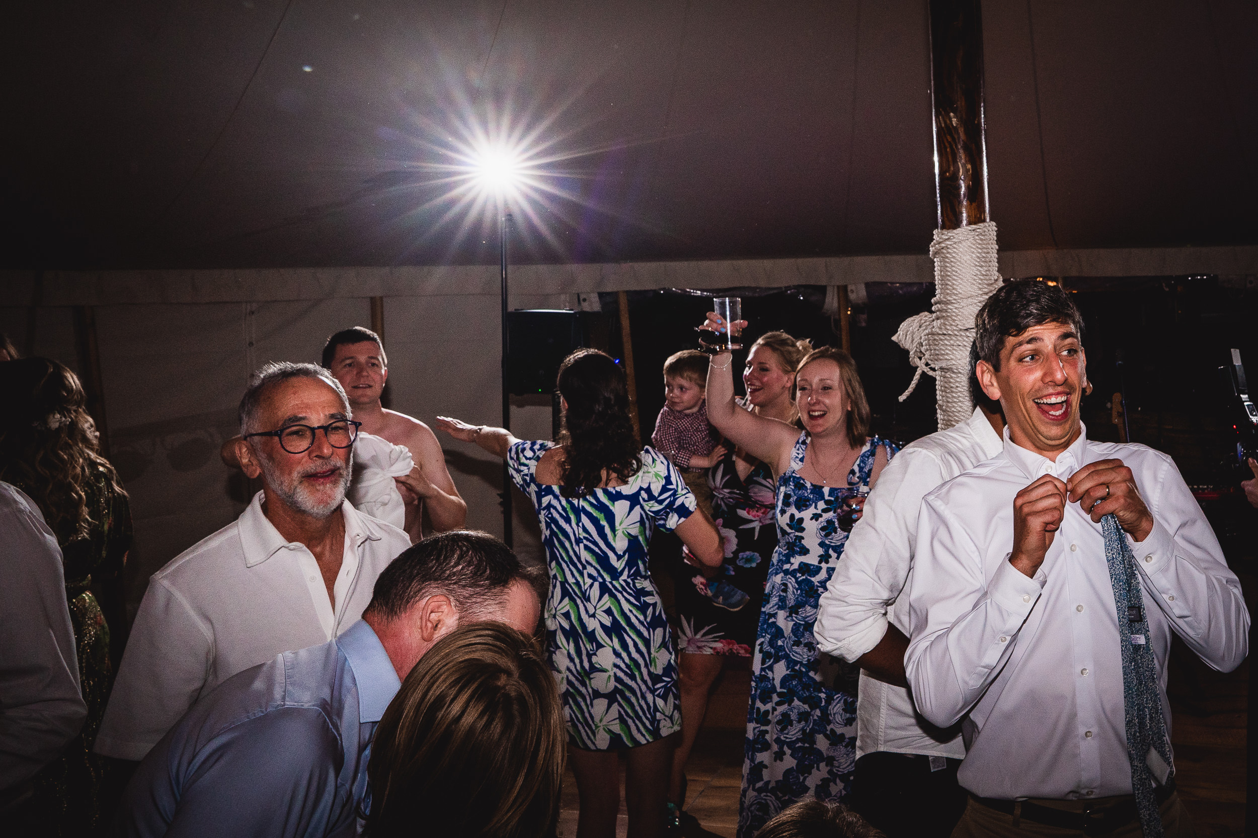 A bride and wedding party dancing in a tent.