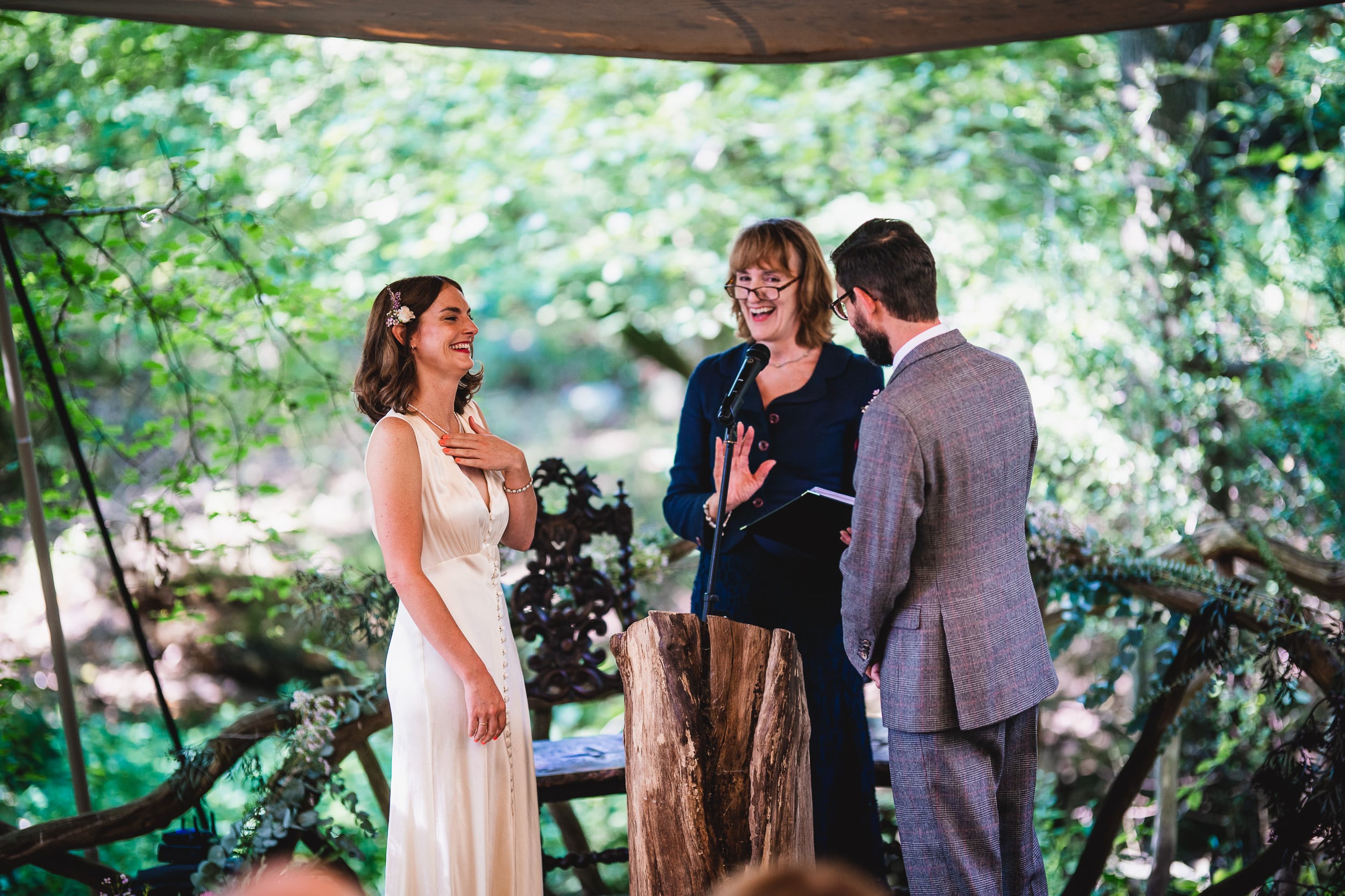 A surreal Surrey wedding takes place as the bride and groom joyfully exchange vows amidst the serene beauty of Ridge Farm's enchanting woods.