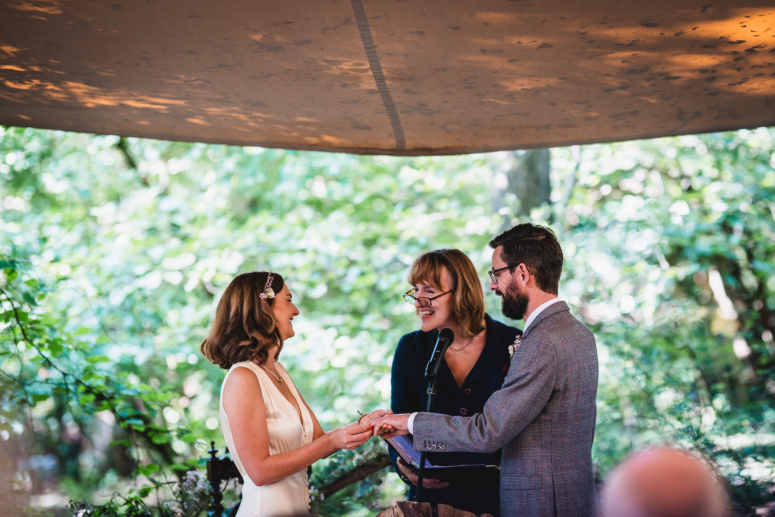 A Surrey Wedding at Ridge Farm, with the bride and groom exchanging their vows under a tent.