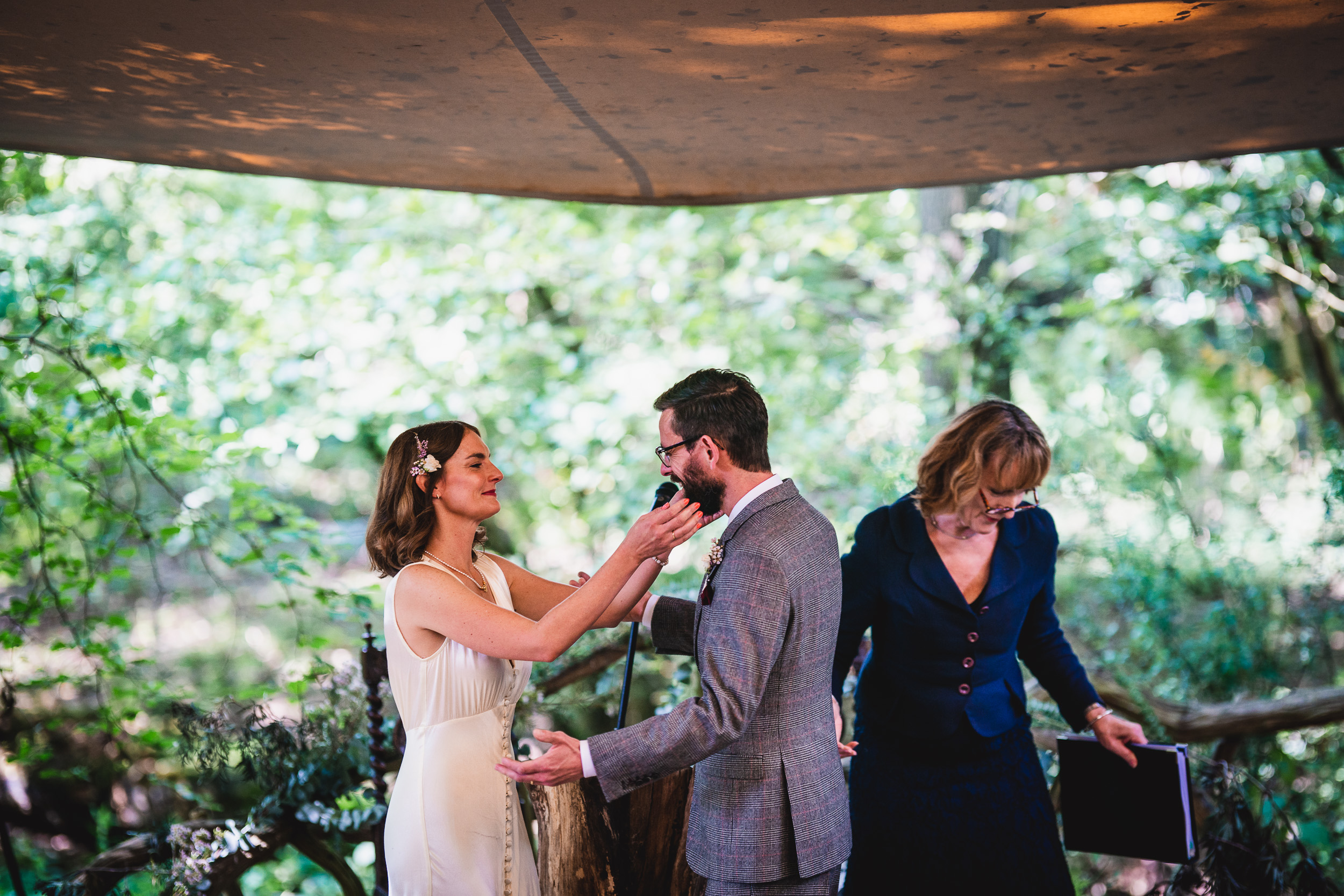 A bride and groom getting ready for their Surrey wedding ceremony in a tent at Ridge Farm.