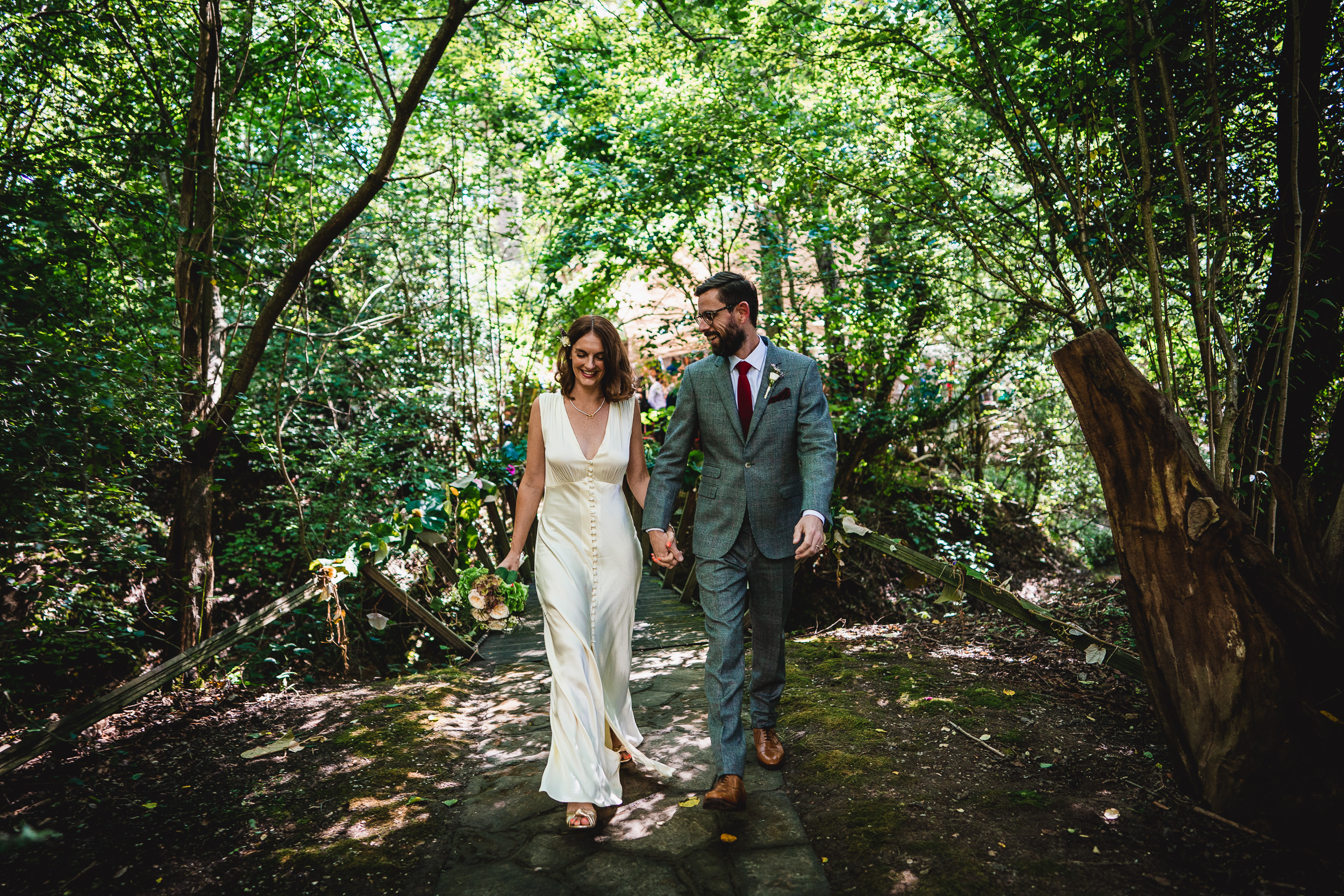 A Surrey wedding couple strolling through the enchanting woods of Ridge Farm.