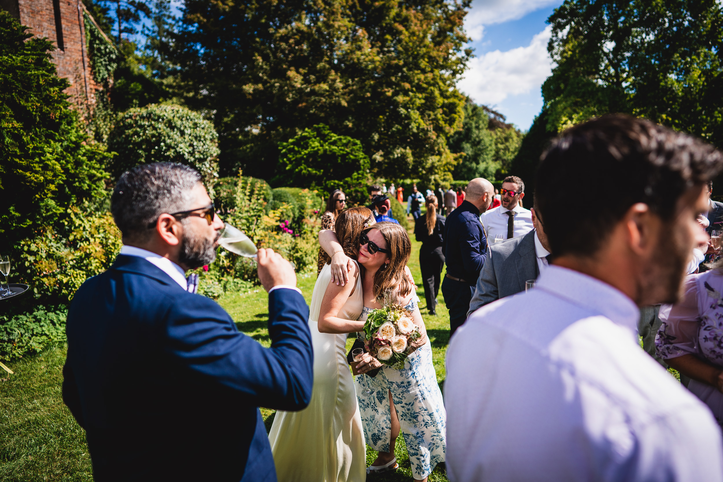 A Surrey Wedding party in a garden at Ridge Farm featuring a beautiful bride and groom.