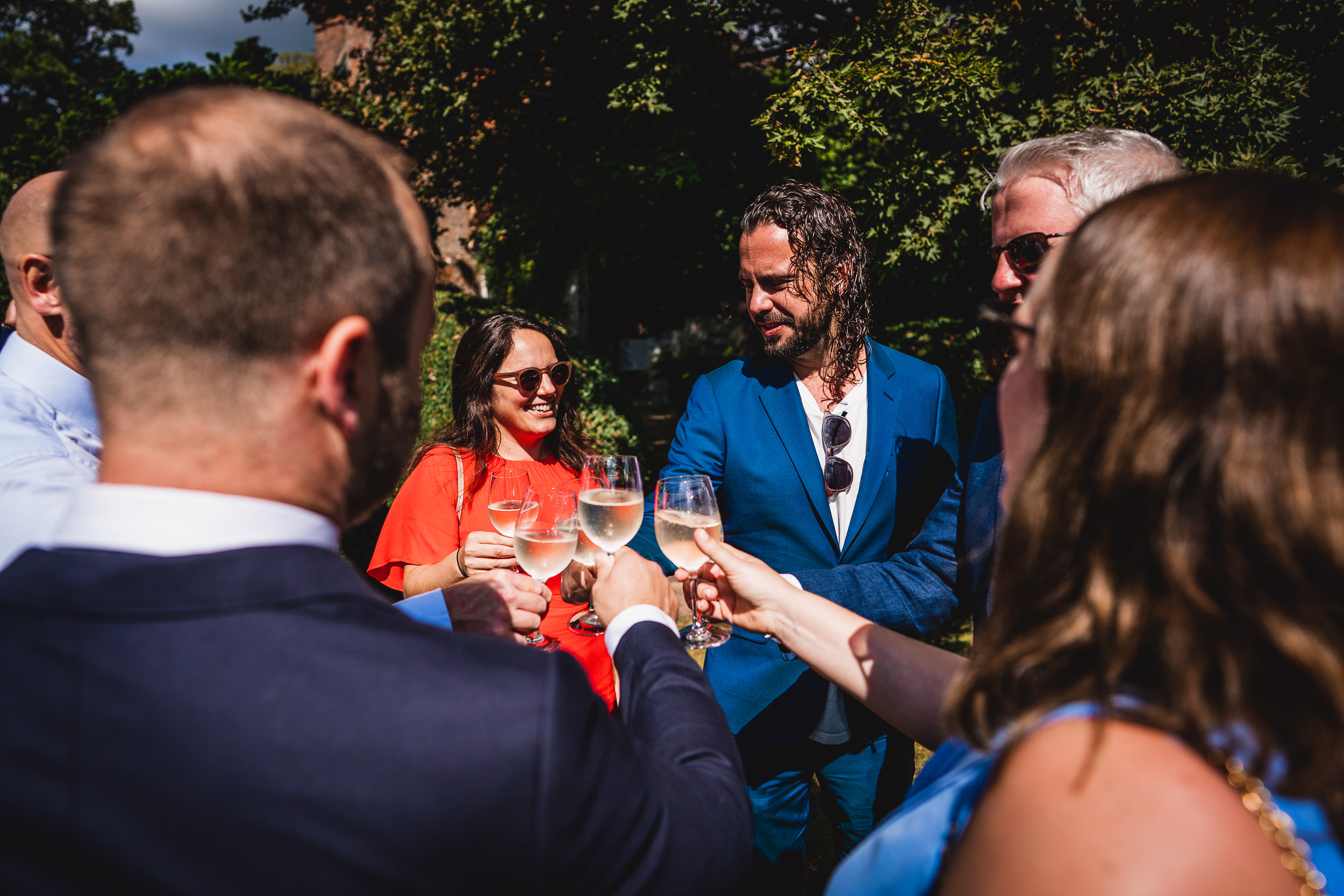 A group of people toasting champagne at a Surrey wedding.
