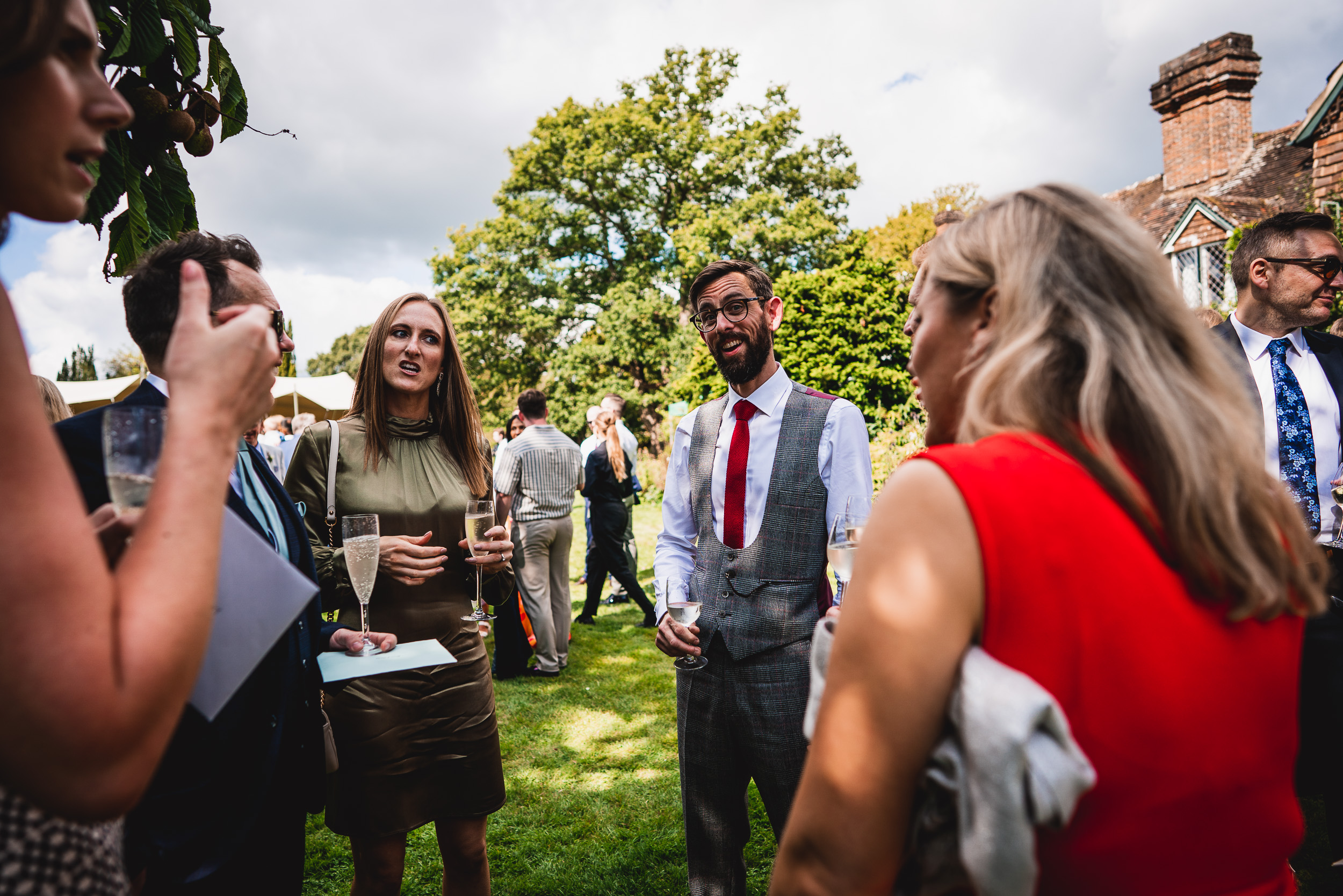 A group of people talking at a Surrey Wedding at Ridge Farm.