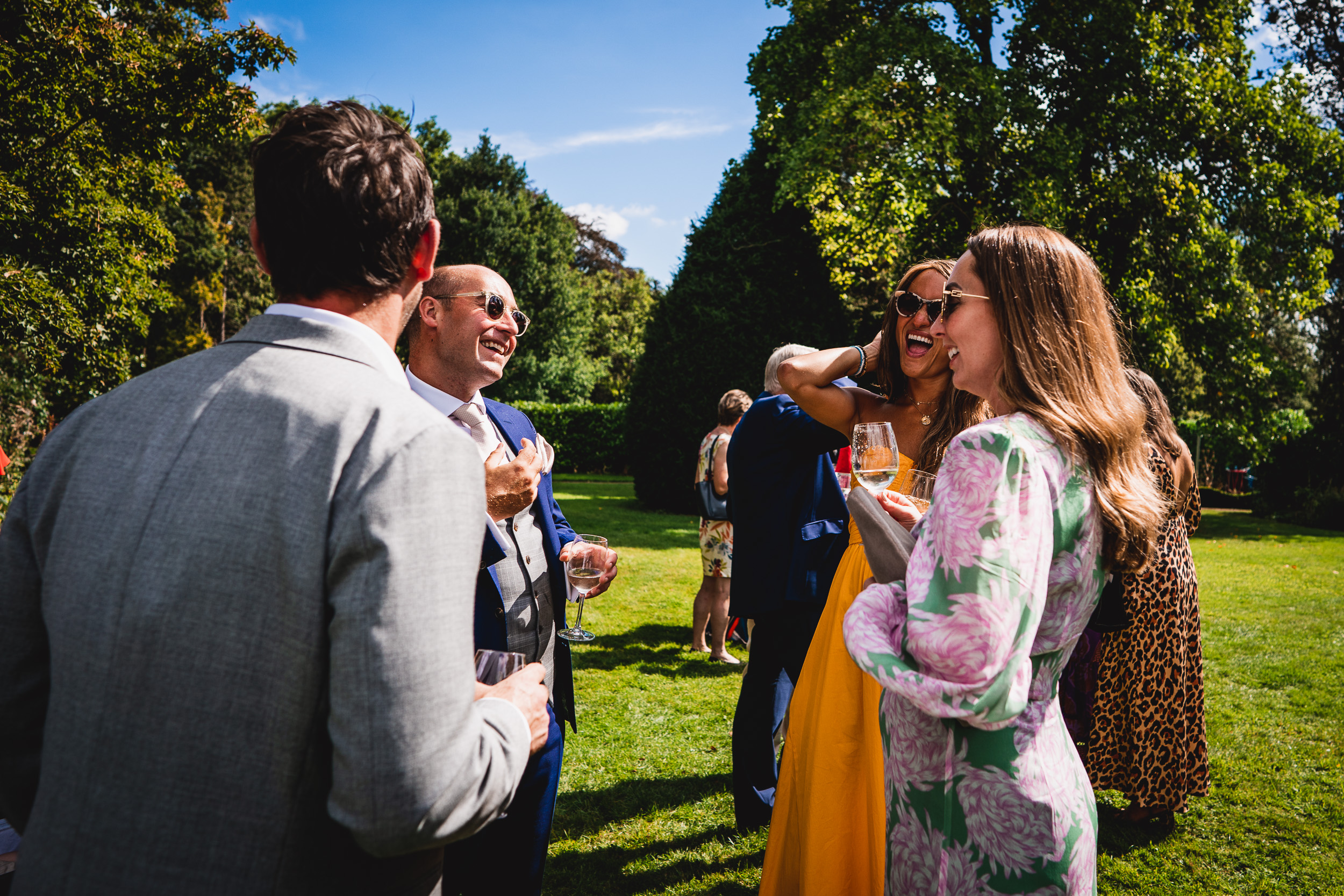 A group of people in a Surrey wedding garden talking to each other.