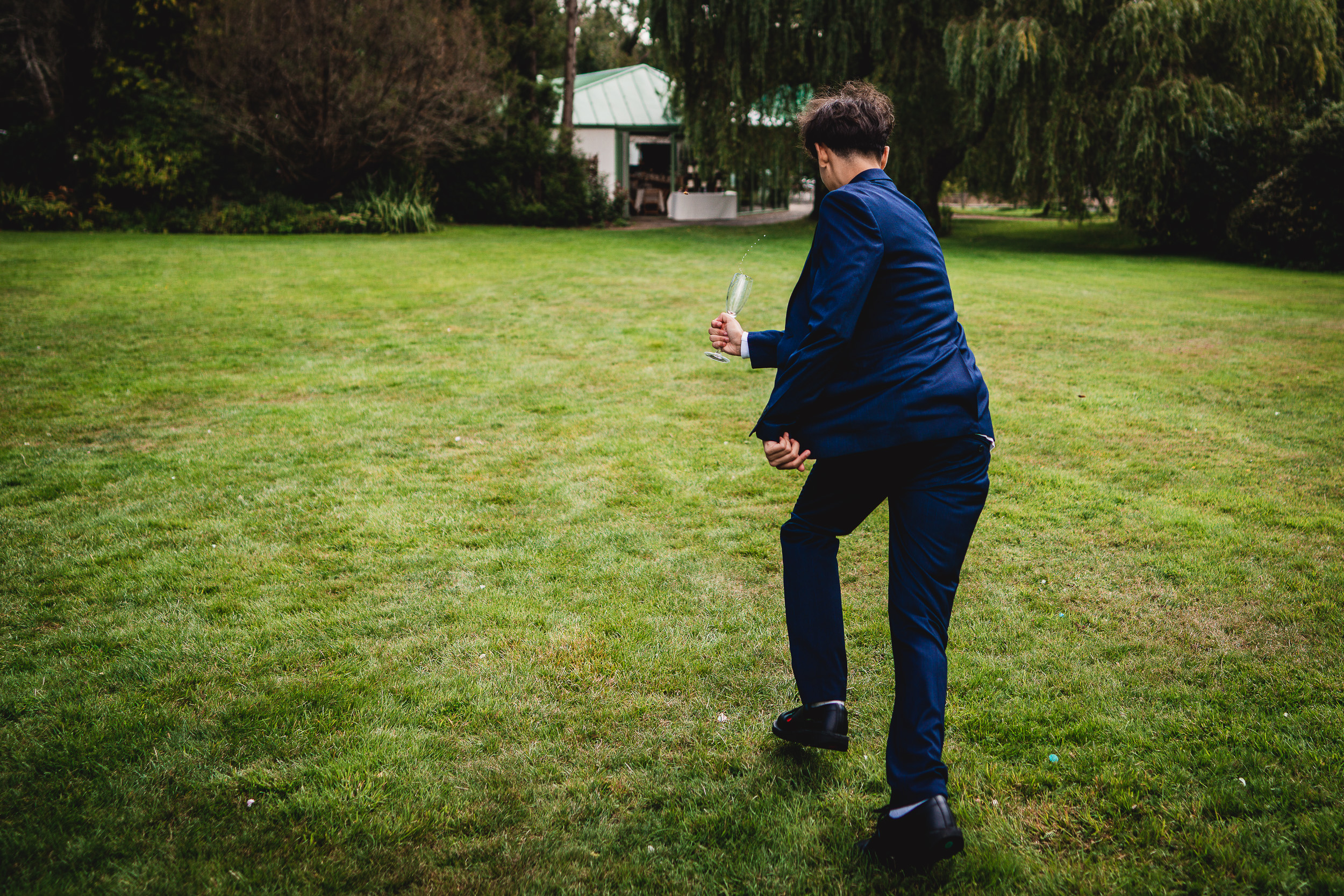 A man in a suit is throwing a frisbee in Ridge Farm, Surrey.