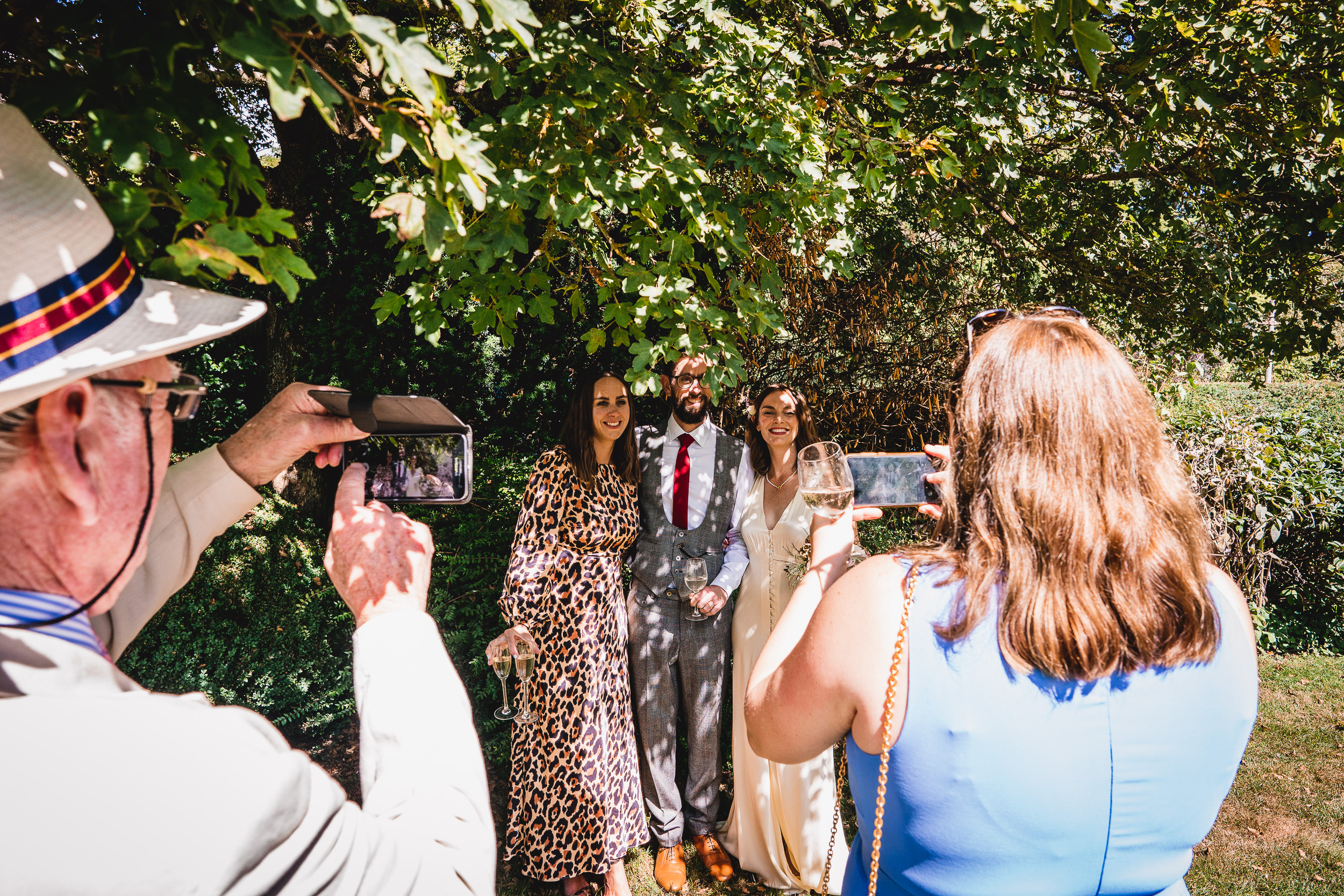 A group of people taking a picture of a Surrey wedding.
