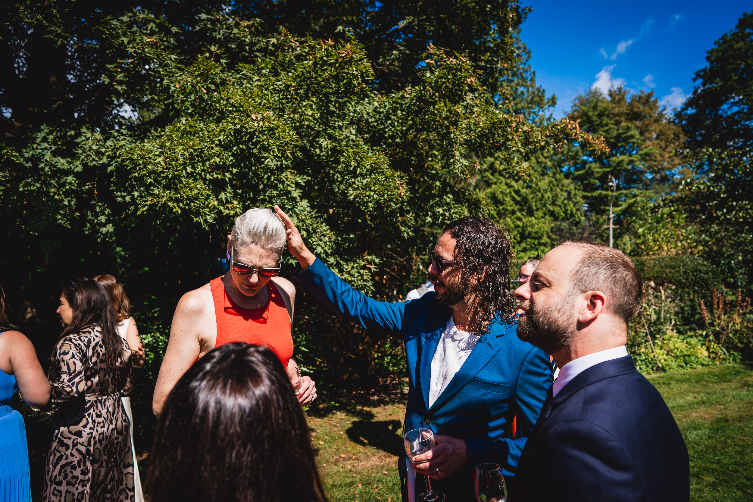 A group of people gathered around a man in a suit at Ridge Farm in Surrey for a wedding.