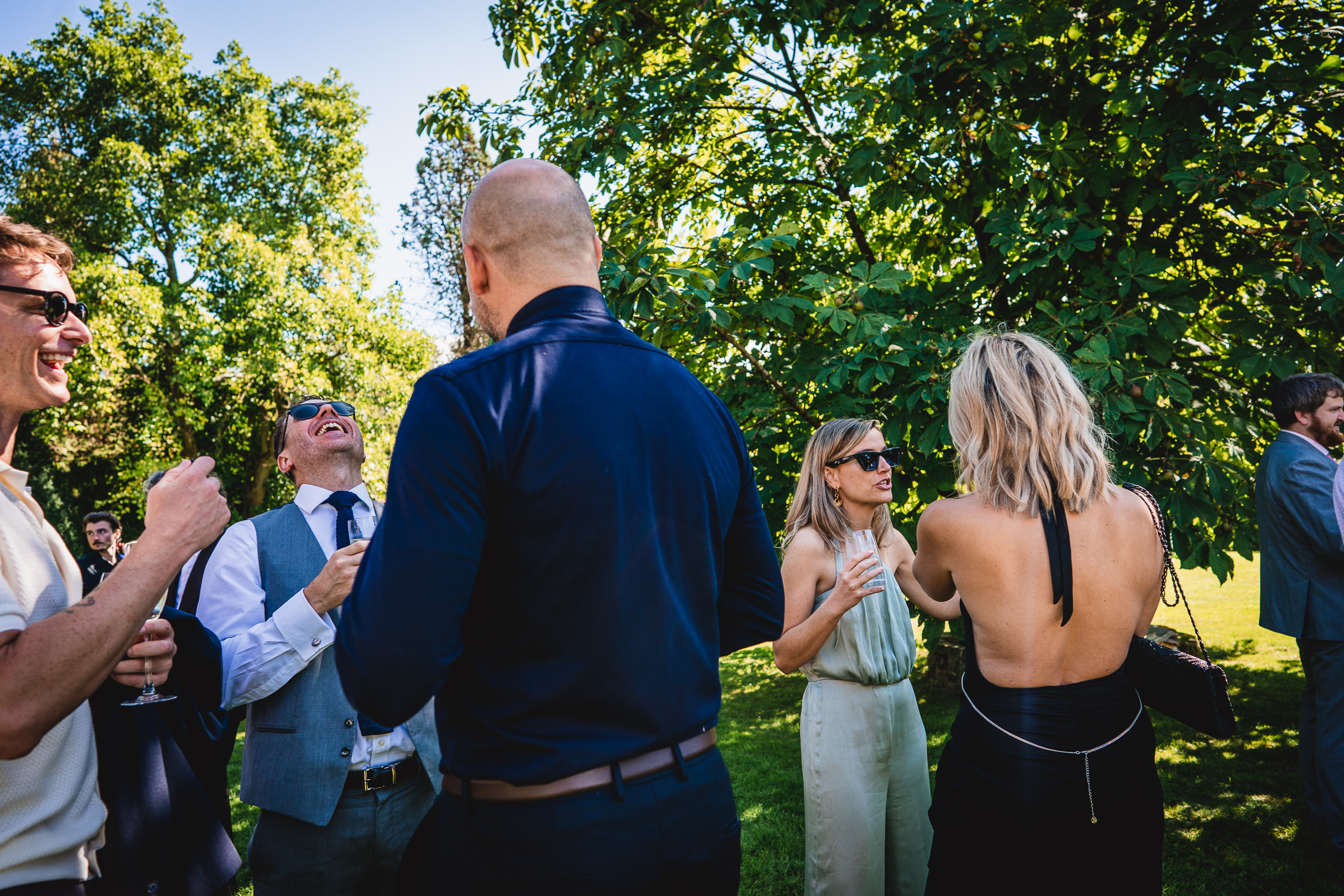A group of people gathered around a Ridge Farm tree in Surrey during a wedding celebration.