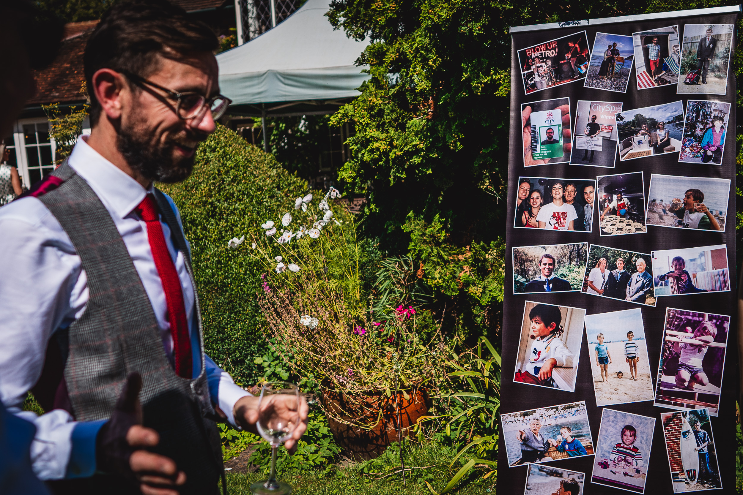A man is standing next to a board with pictures on it at Ridge Farm in Surrey for a wedding.