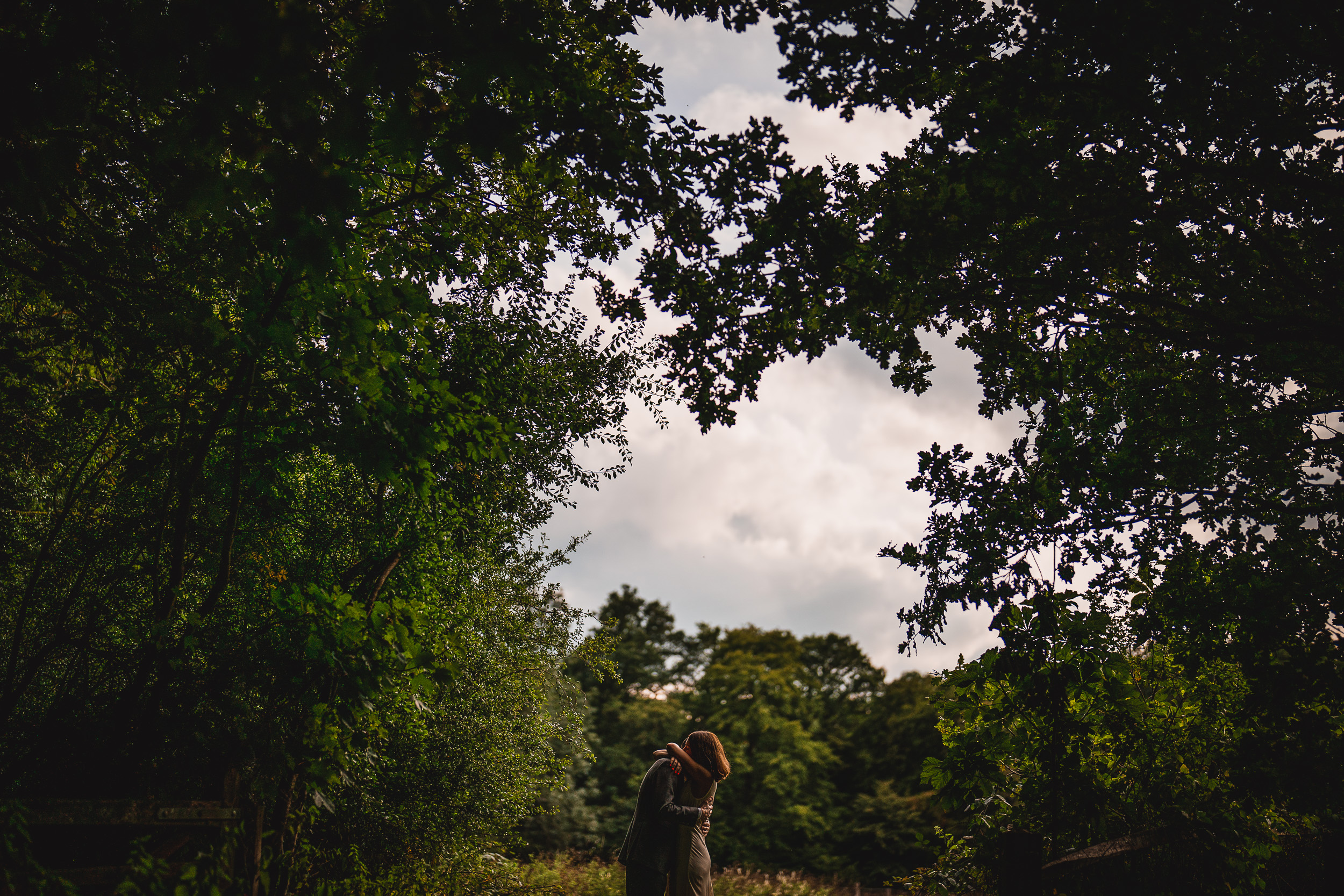 A woman is standing in the middle of a wooded area at Ridge Farm in Surrey, captured during a wedding ceremony.