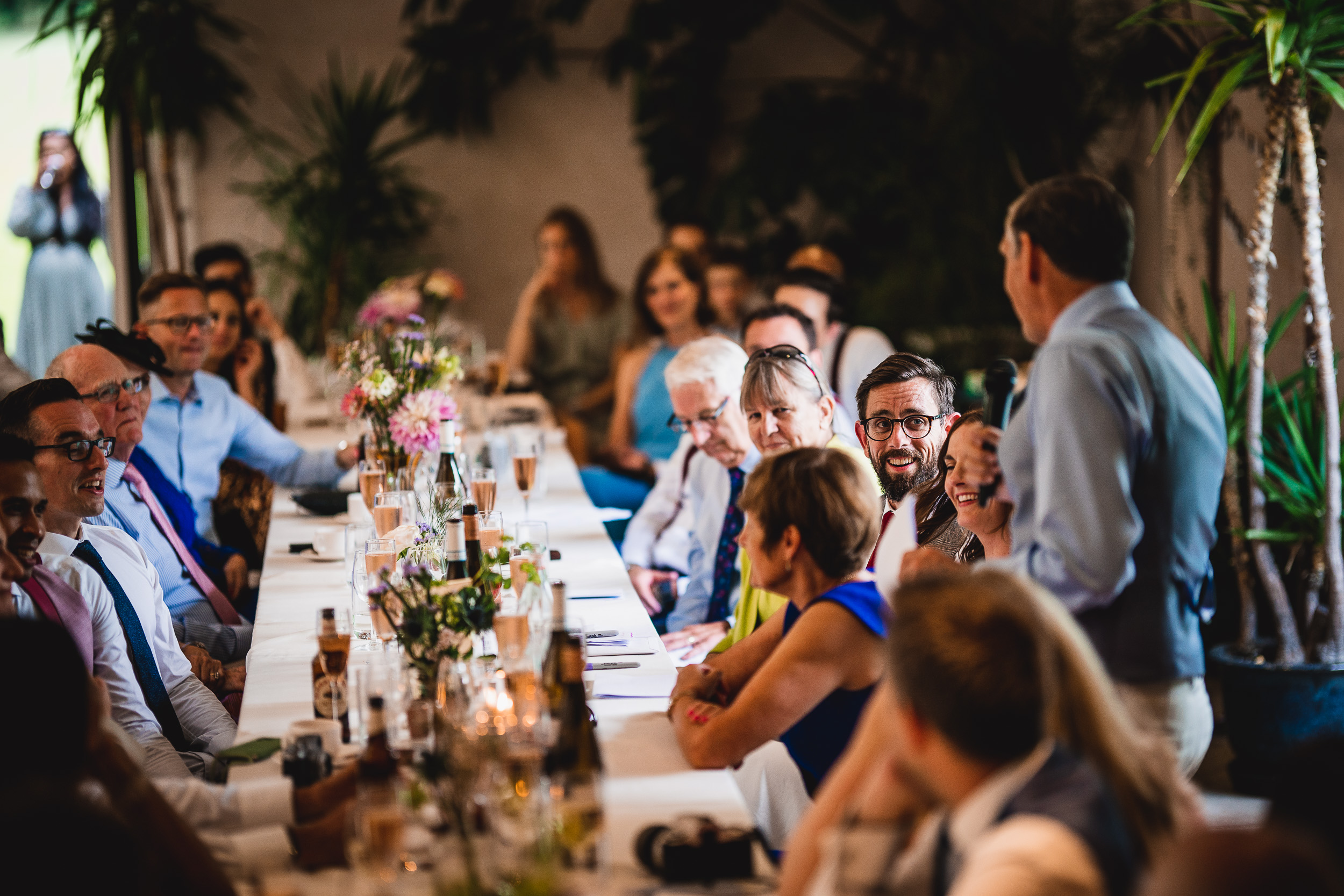 A group of people sitting around a long table at a Surrey wedding reception.